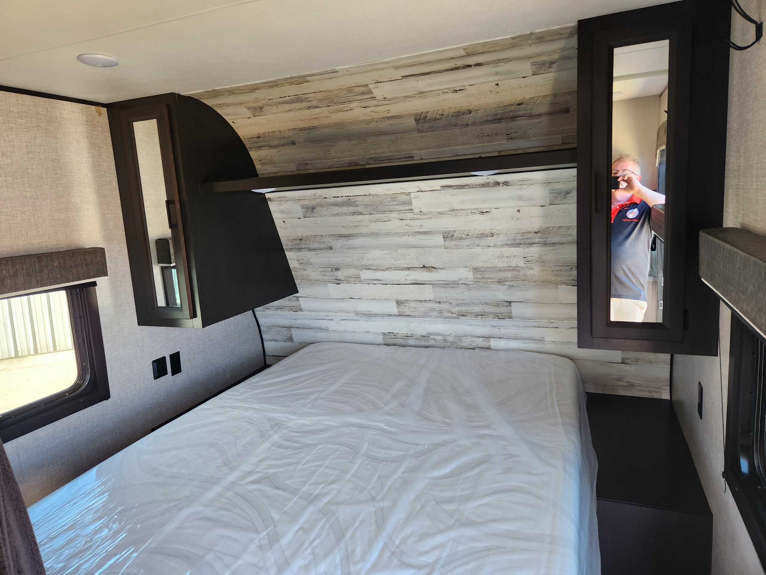 Ready for your adventure, this RV rental bedroom features a clean bed, modern wood-panel headboard, and convenient storage.. Jayco Jay Flight 2023