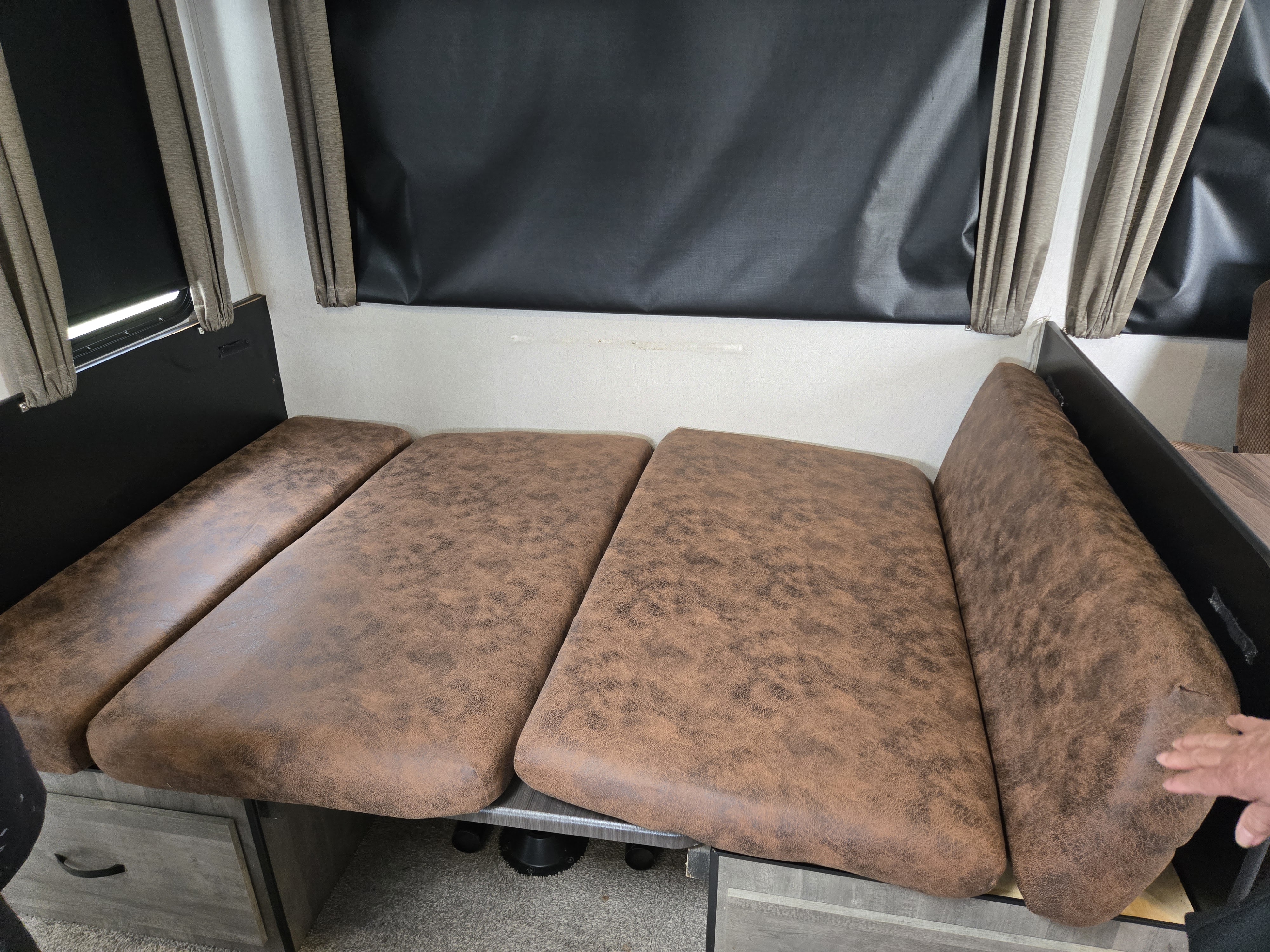 Comfortable RV rental: versatile brown cushioned dinette area with blinds & storage, converts into a bed.. Forest River Vibe 2020