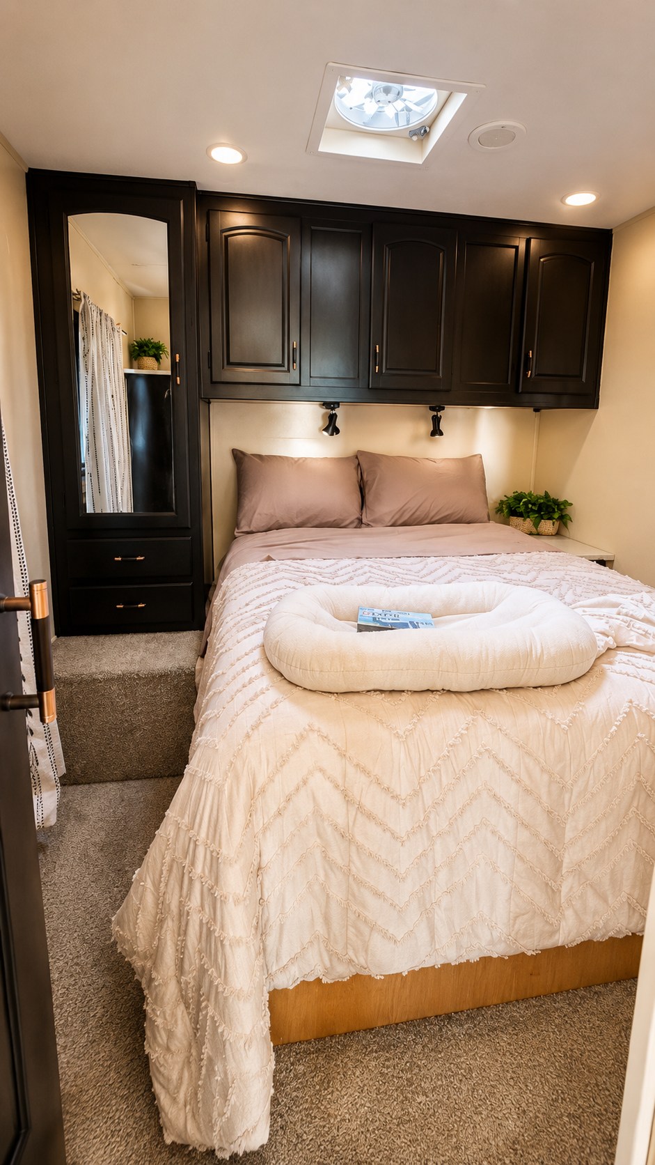 Inviting RV rental bedroom with dark wood cabinets, a comfortable bed, overhead lights, and a mirrored wardrobe. Features a ceiling fan.. Jayco Greyhawk 2007