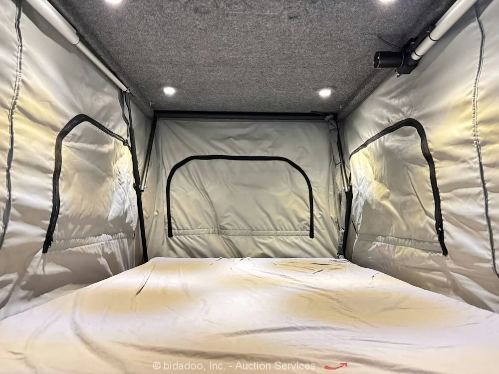 RV rental: Inside a cozy pop-top camper's sleeping area with a bed, fabric walls, ceiling lights, and ventilation.. Ford Custom Transit 2023