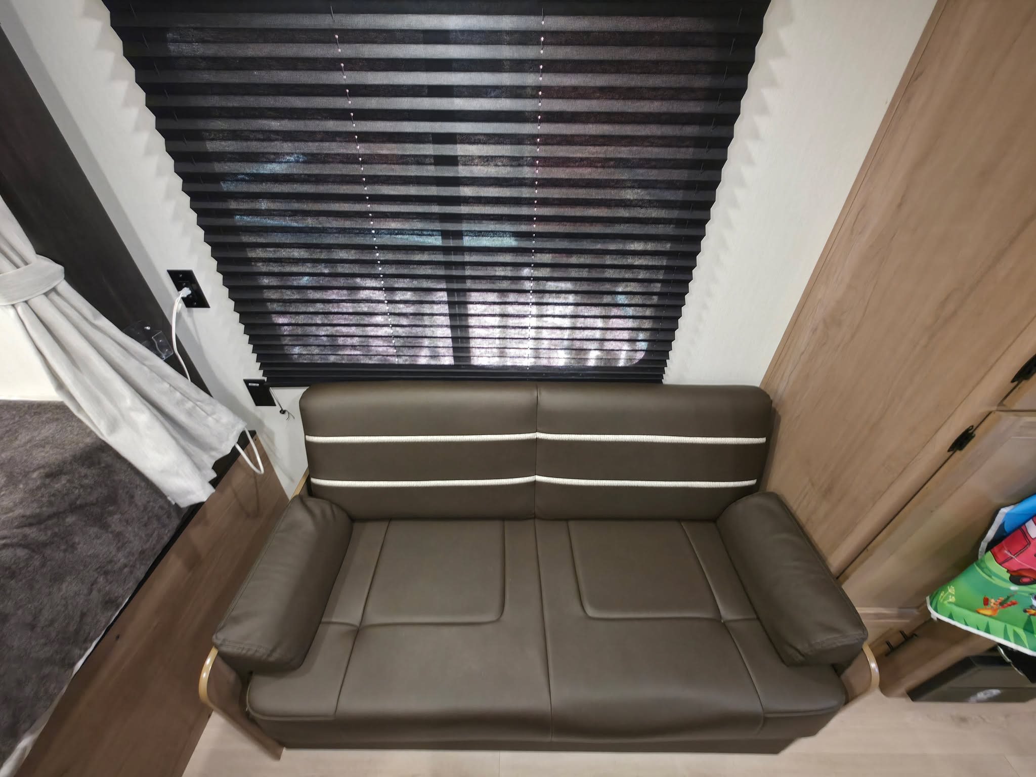 Relax in this cozy RV rental's interior, featuring a brown sofa, dark window blinds, and a comfortable living space.. Forest River 19SM 2025