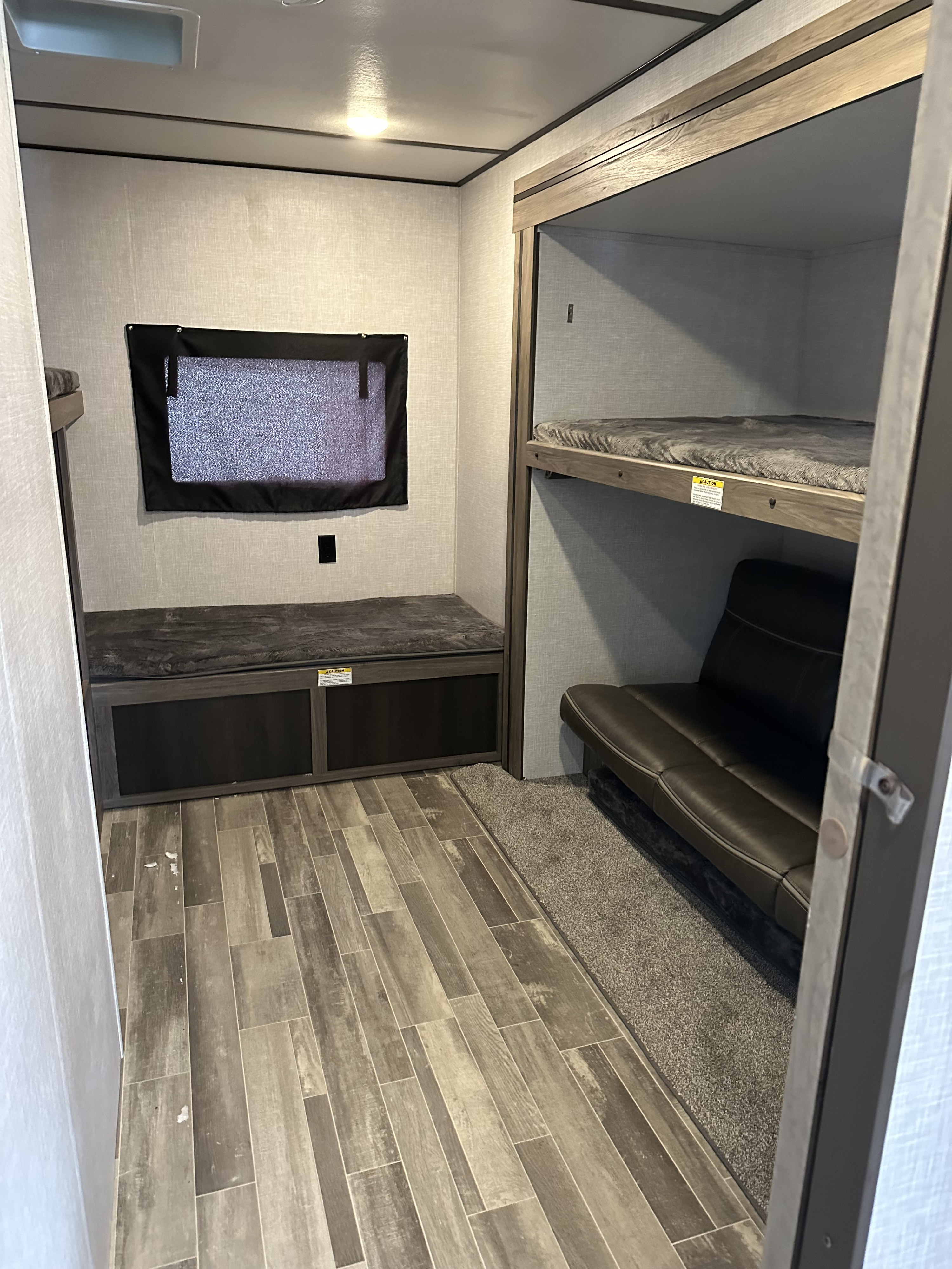 RV rental bunk area: Lower bunk with storage, window, and a set of bunk beds over a sofa. Perfect for RV trips.. Crossroads RV Zinger 2021