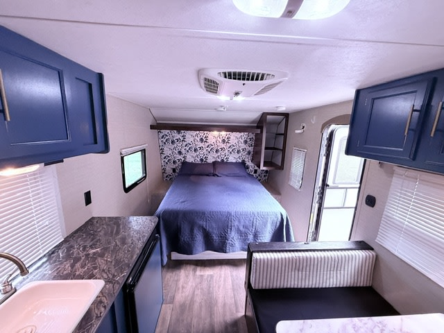 Cozy RV rental interior featuring a queen bed, kitchenette, dinette, and ample storage for comfortable travel.. Keystone RV Summerland Mini 2016
