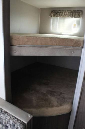 This RV rental features cozy bunk beds with mattresses, a window with blinds, and a compact sleeping area.. Keystone RV Hideout LHS 2019