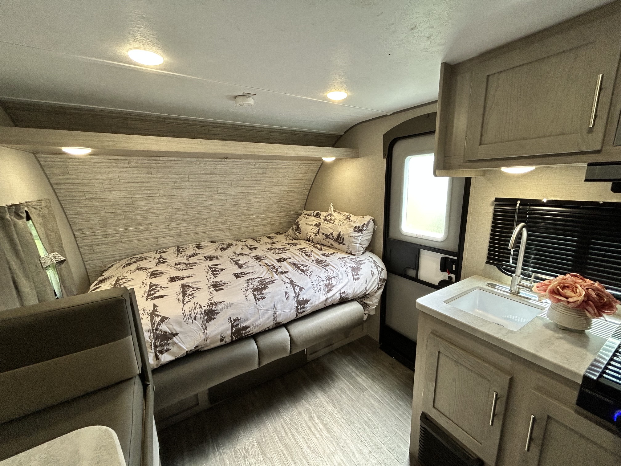 Cozy RV rental interior featuring a comfortable bed, compact kitchen, and dinette for your next travel adventure.. Forest River Aurora Aurora Light 2023