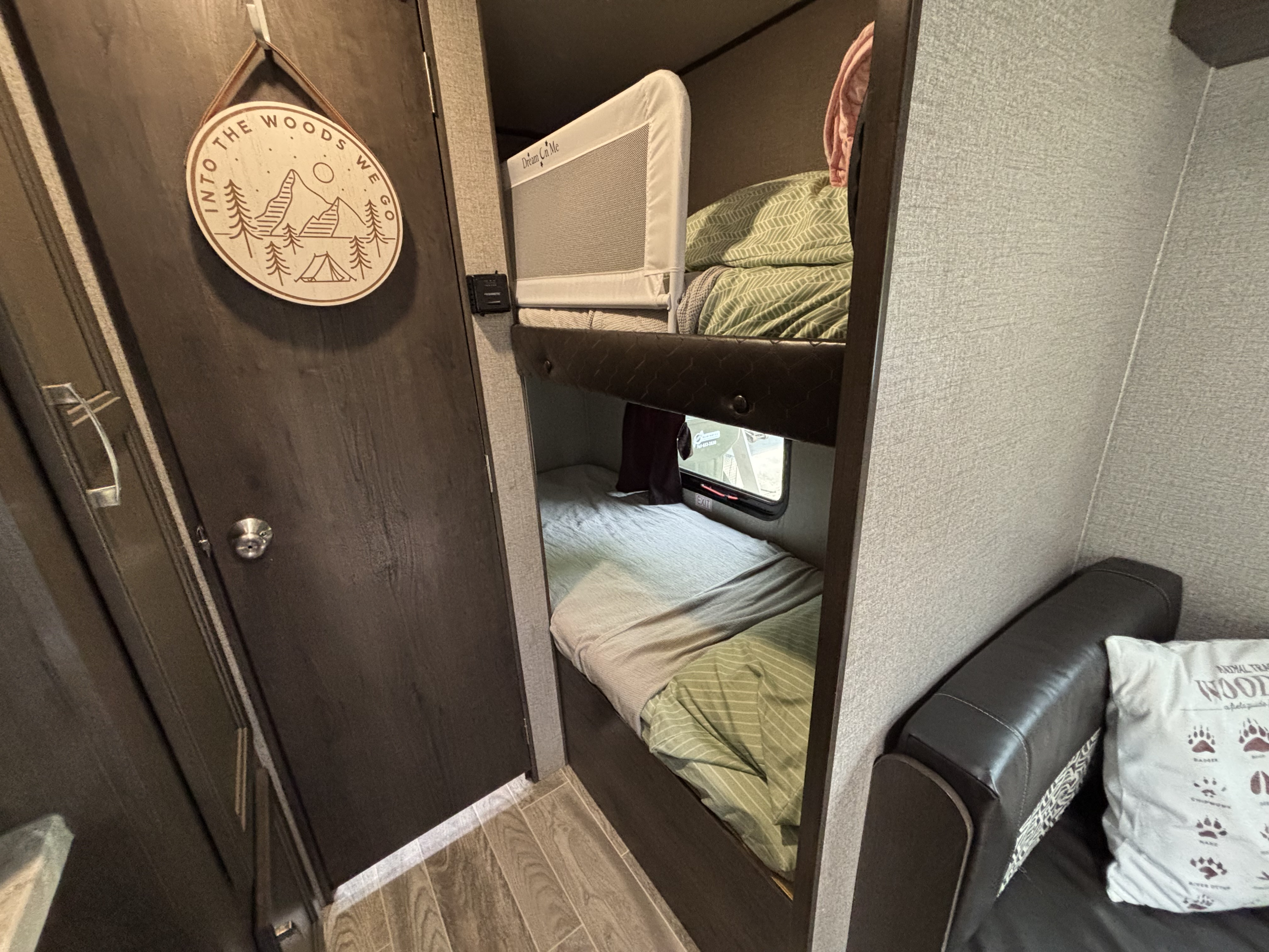 This rv rental offers cozy bunk beds with a 'Dream On Me' safety rail, 'Into The Woods We Go' decor, and a window view.. Jayco Jay Flight SLX 2021