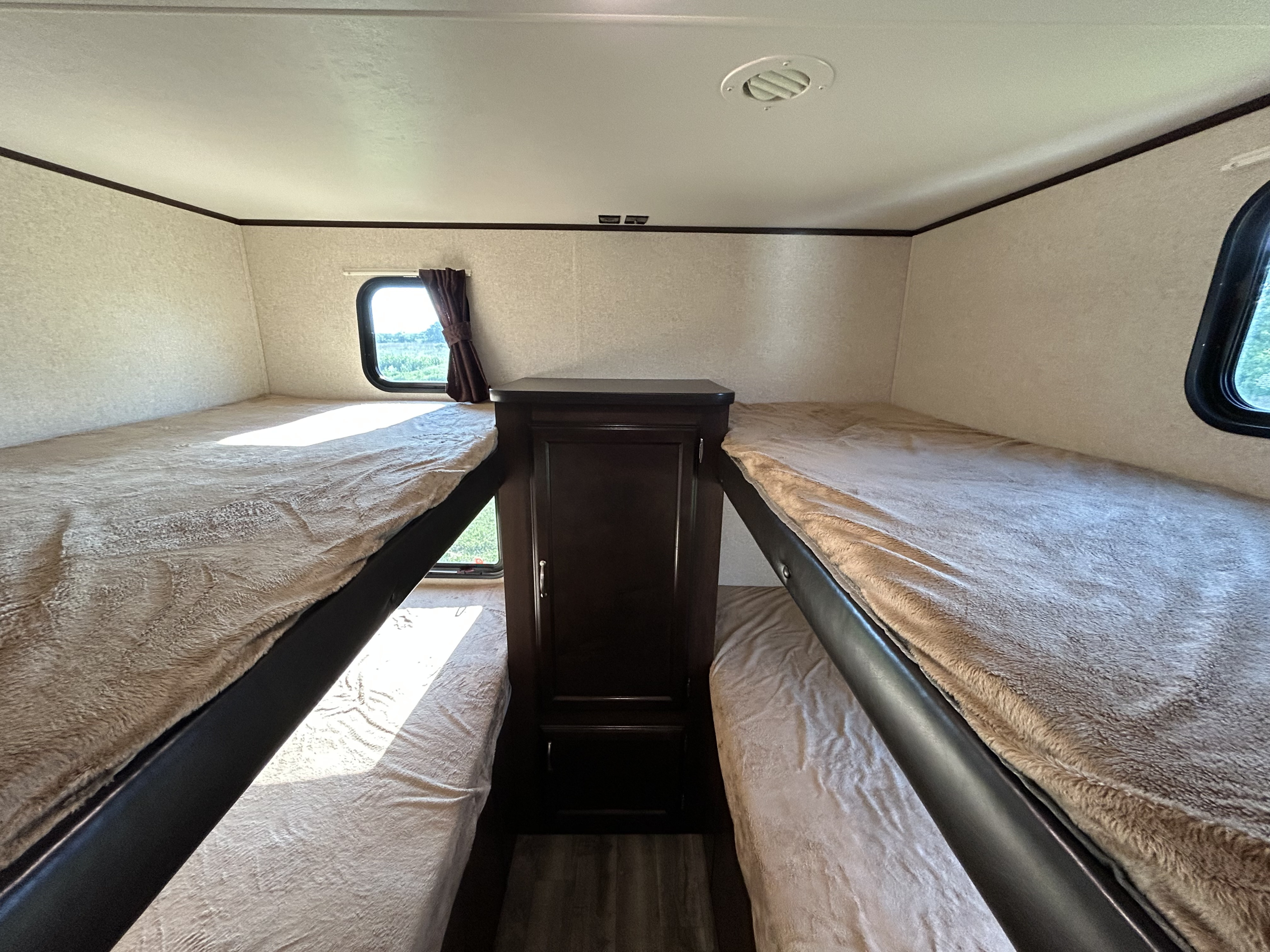 RV rental bunk bed area: two cozy sets of beds with soft blankets, windows, and a central storage cabinet for family trips.. Jayco Jay Flight SLX 2018