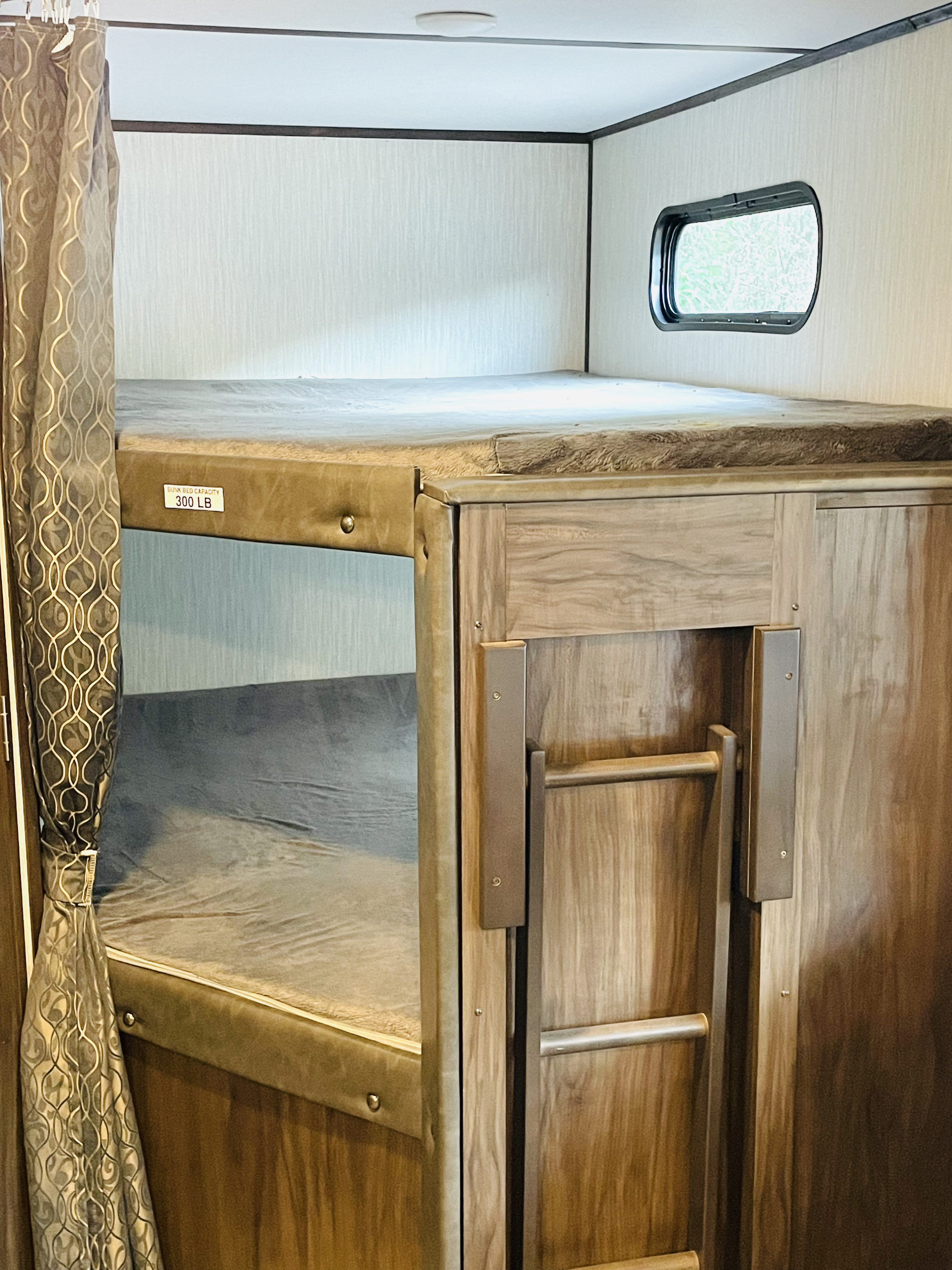 Cozy **RV rental** bunk beds with 300 lb capacity, window, and integrated ladder. Perfect for family travel.. Forest River Cherokee Alpha Wolf 2019