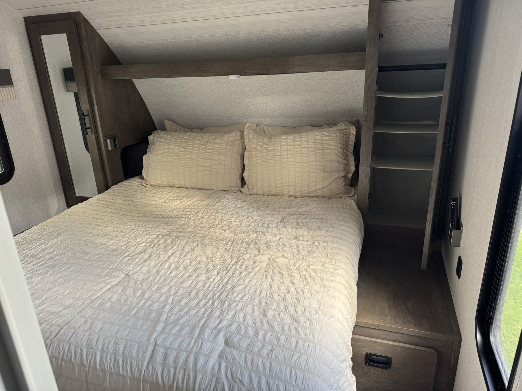 RV rental bedroom with a comfortable bed, mirrored wardrobe, and built-in storage on the right, perfect for travelers.. Forest River Salem Cruise Lite 2022