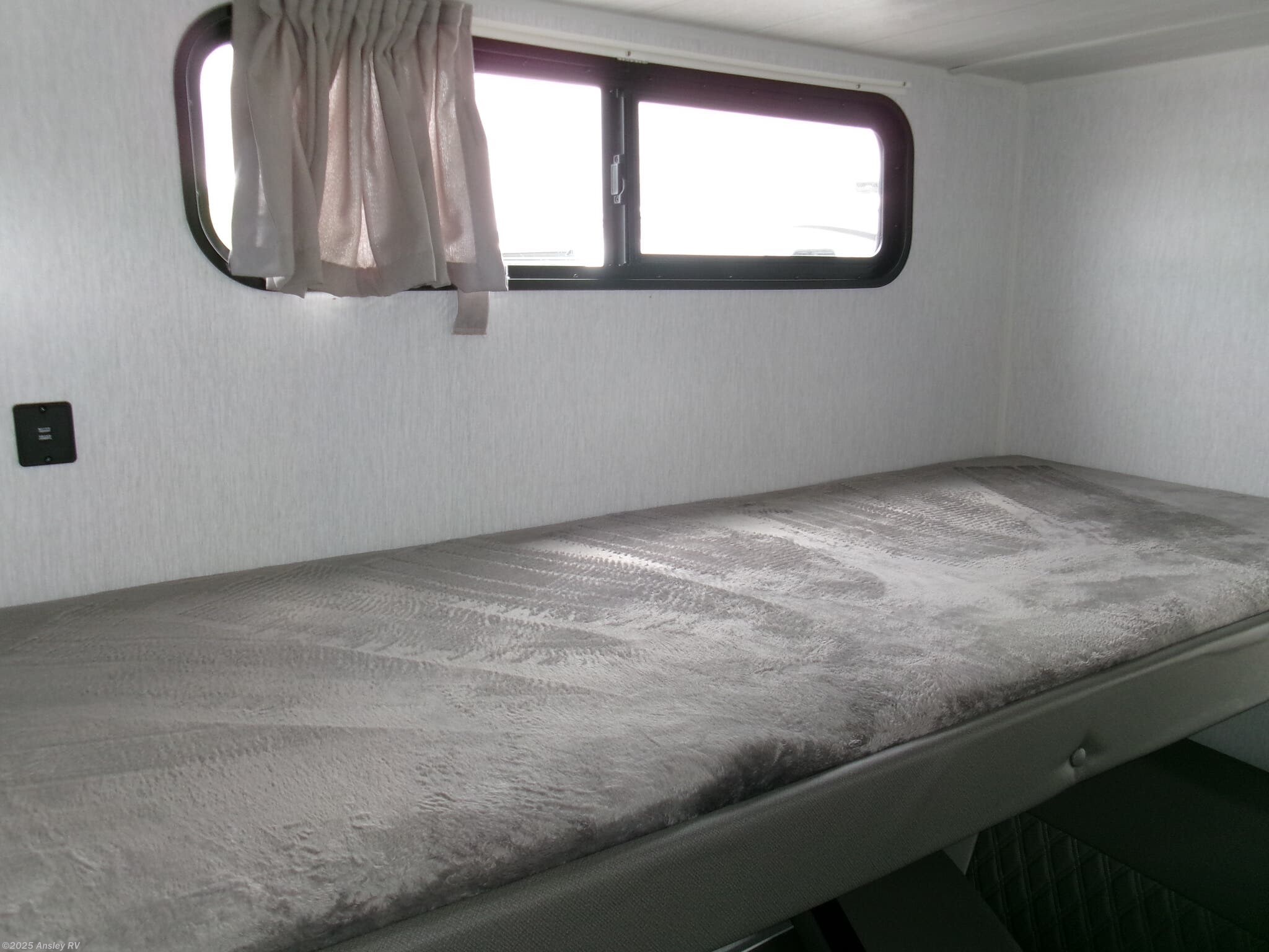 RV rental bunk bed with window, curtains, and wall outlet. A cozy sleeping space for your motorhome adventure.. Forest River Salem Cruise Lite 2022