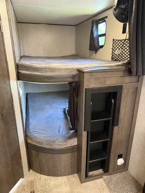 Cozy RV rental bunk beds, perfect for family travel, with a built-in ladder, window, and fan.. Jayco Jay Flight 2021