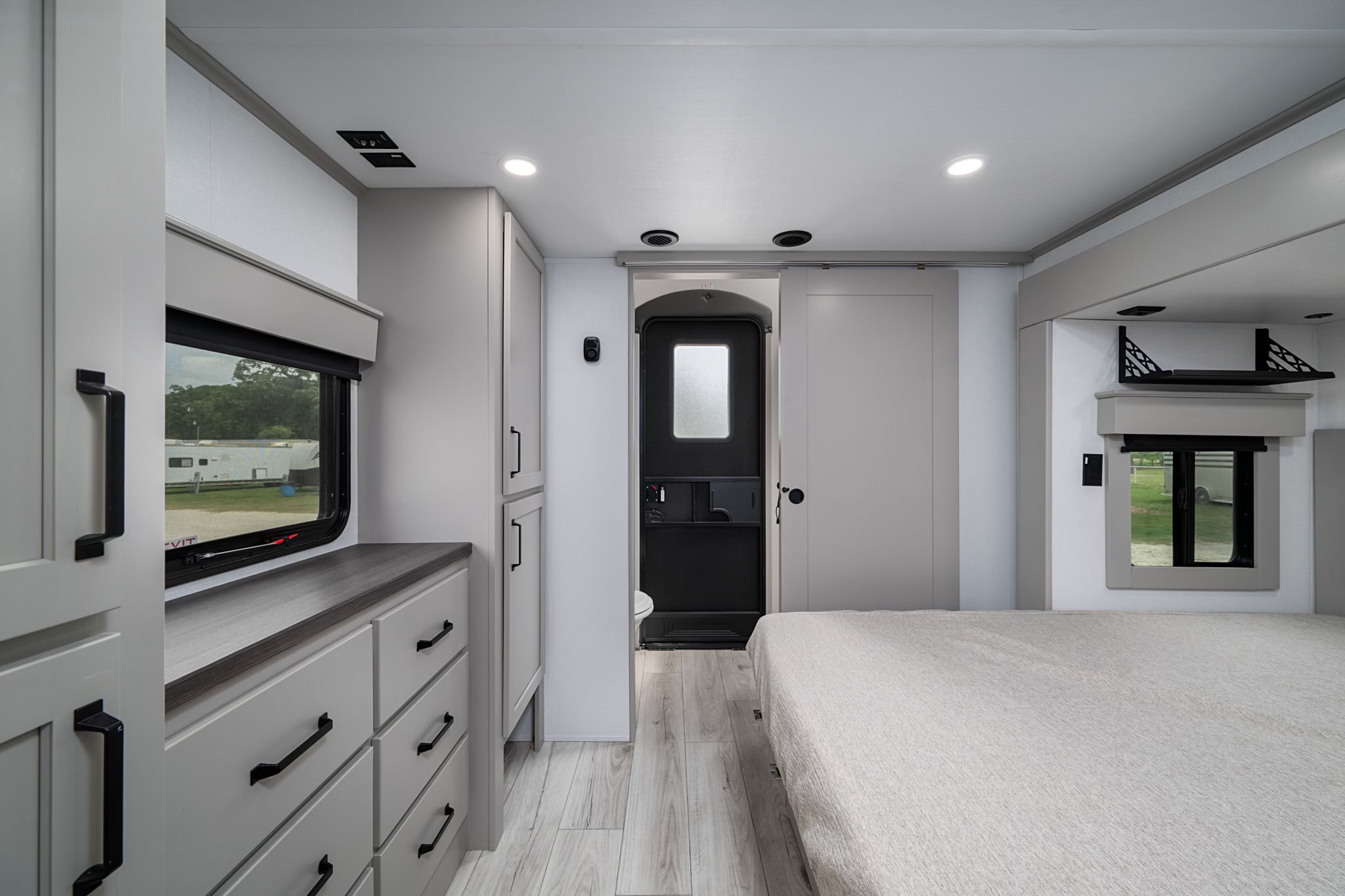 Modern RV rental interior: spacious bedroom with storage, ensuite bath, and bright windows for comfortable travel.. Keystone Montana 2025