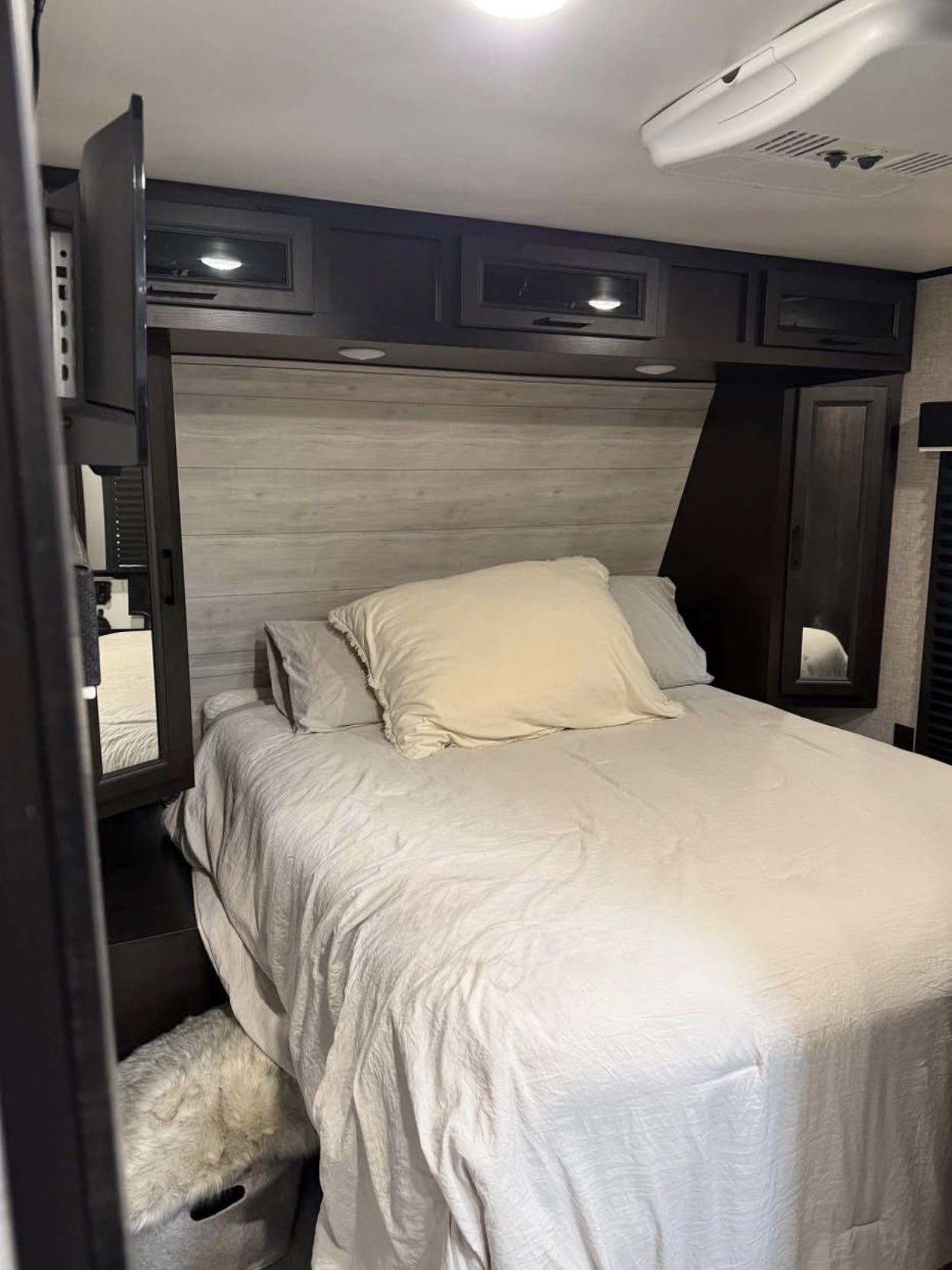 Relax in this comfortable RV rental bedroom, featuring a neatly made bed, overhead storage, and a wall-mounted TV.. Jayco Jay Flight 2022
