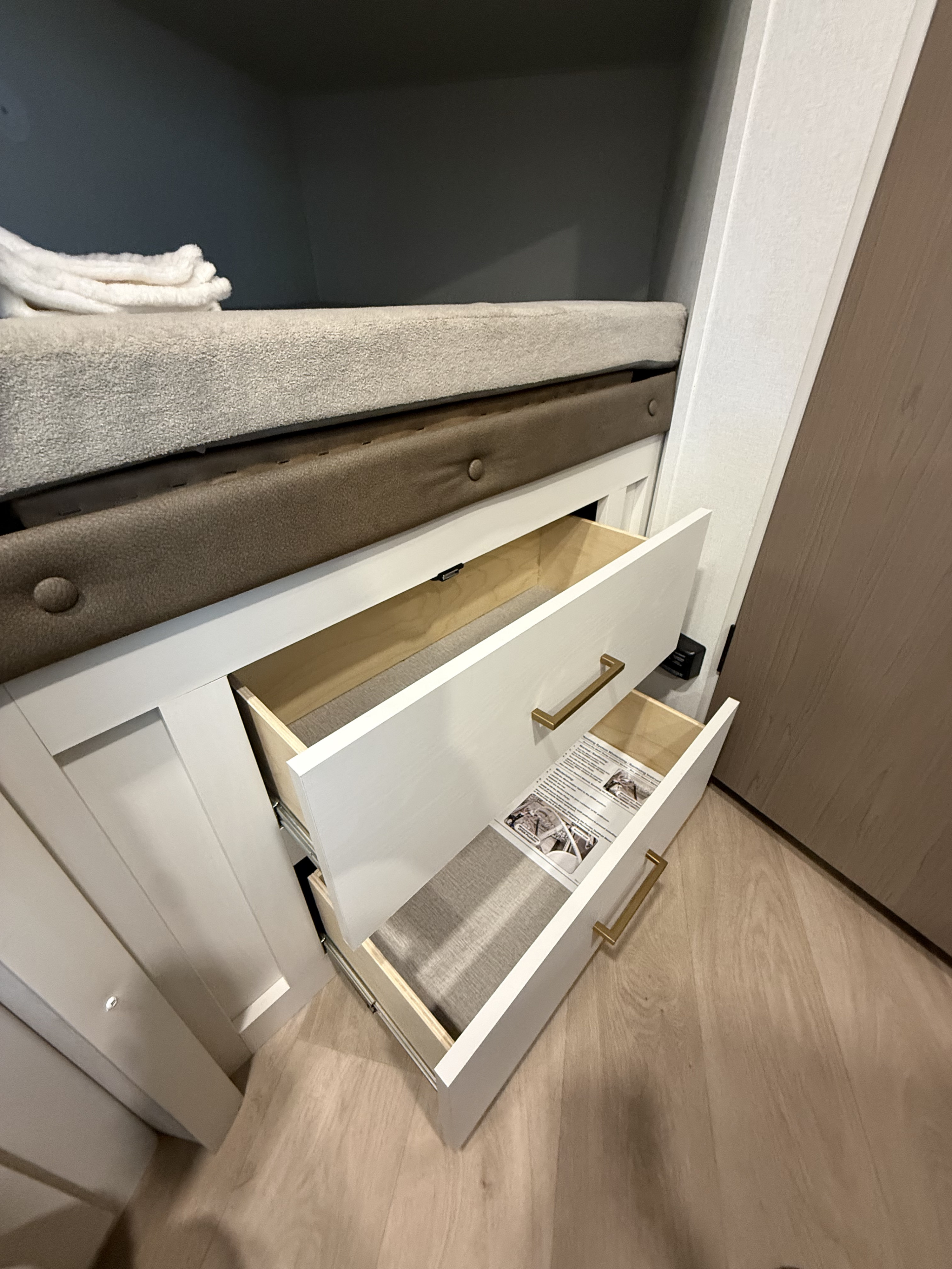 RV rental bunk bed with two open storage drawers below, showcasing practical modern interior organization.. Grand Design Transcend One 2026