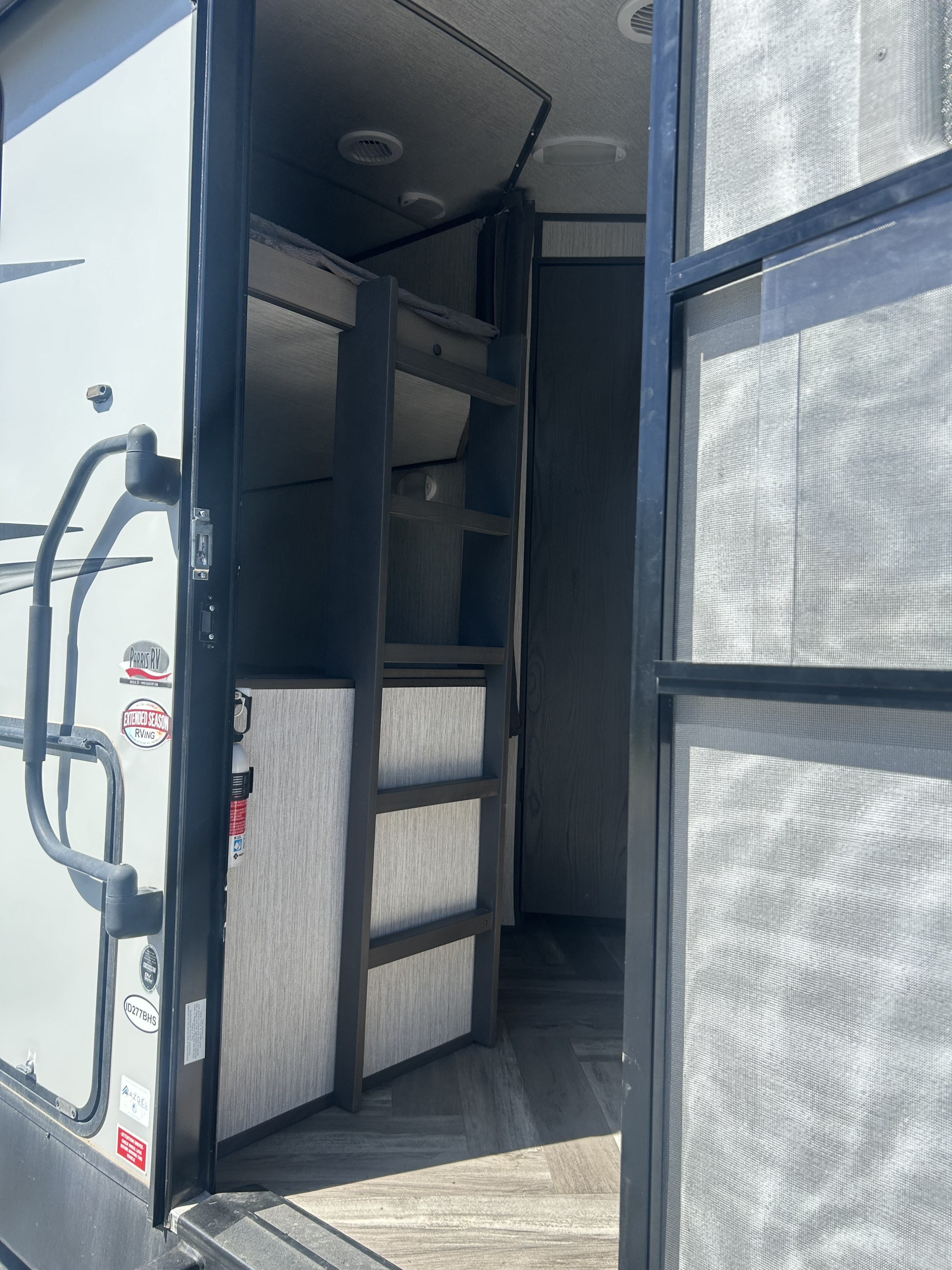 Interior view of an RV rental: open door reveals bunk beds, storage, and a fire extinguisher. Perfect for family adventures.. Cruiser RV Shadow Cruiser 2022