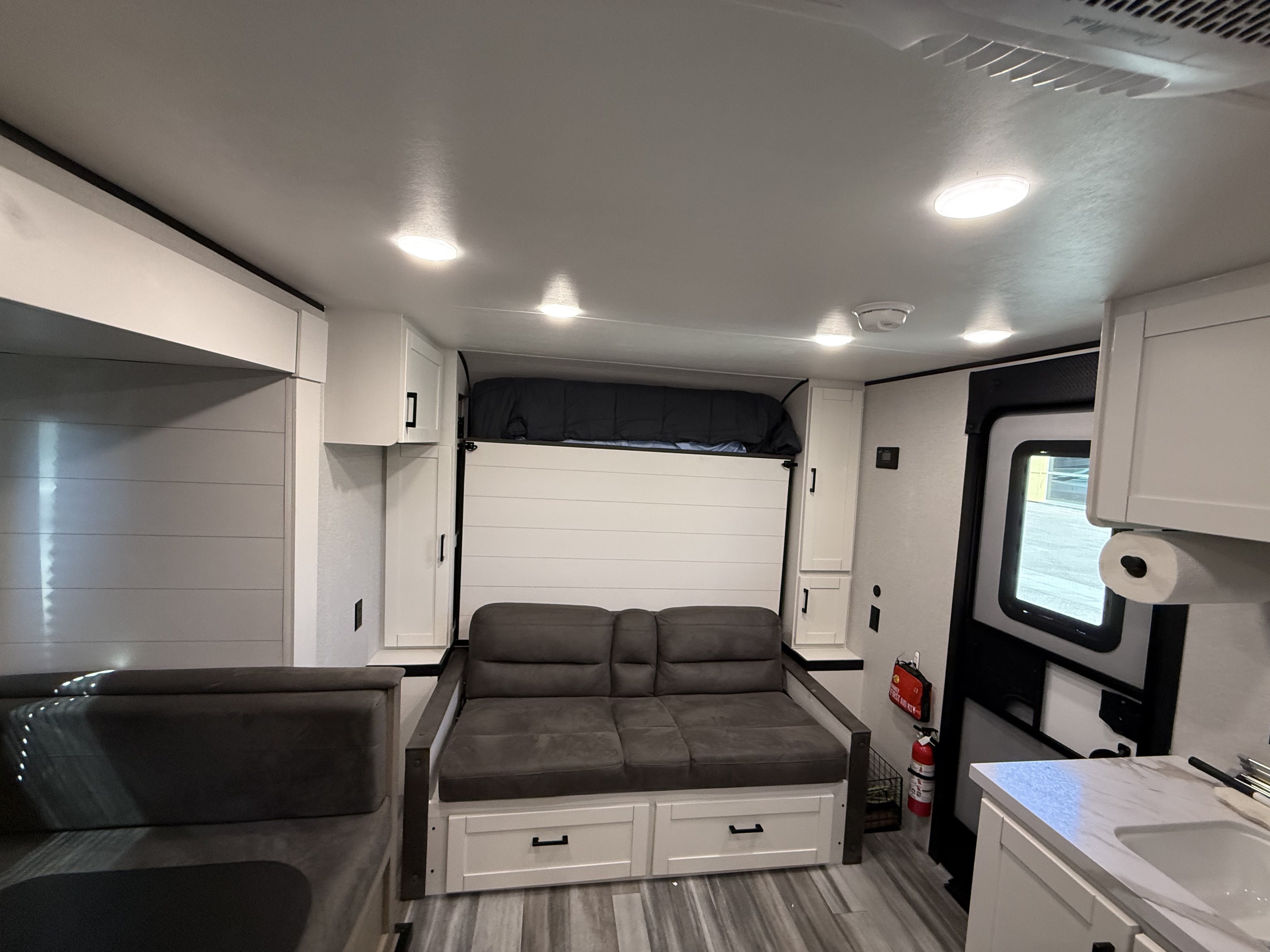 This RV rental interior features a sofa, folded murphy bed, dinette, and kitchen area. Modern and functional design.. Jayco Jay Flight SLX Baja Edition 2025