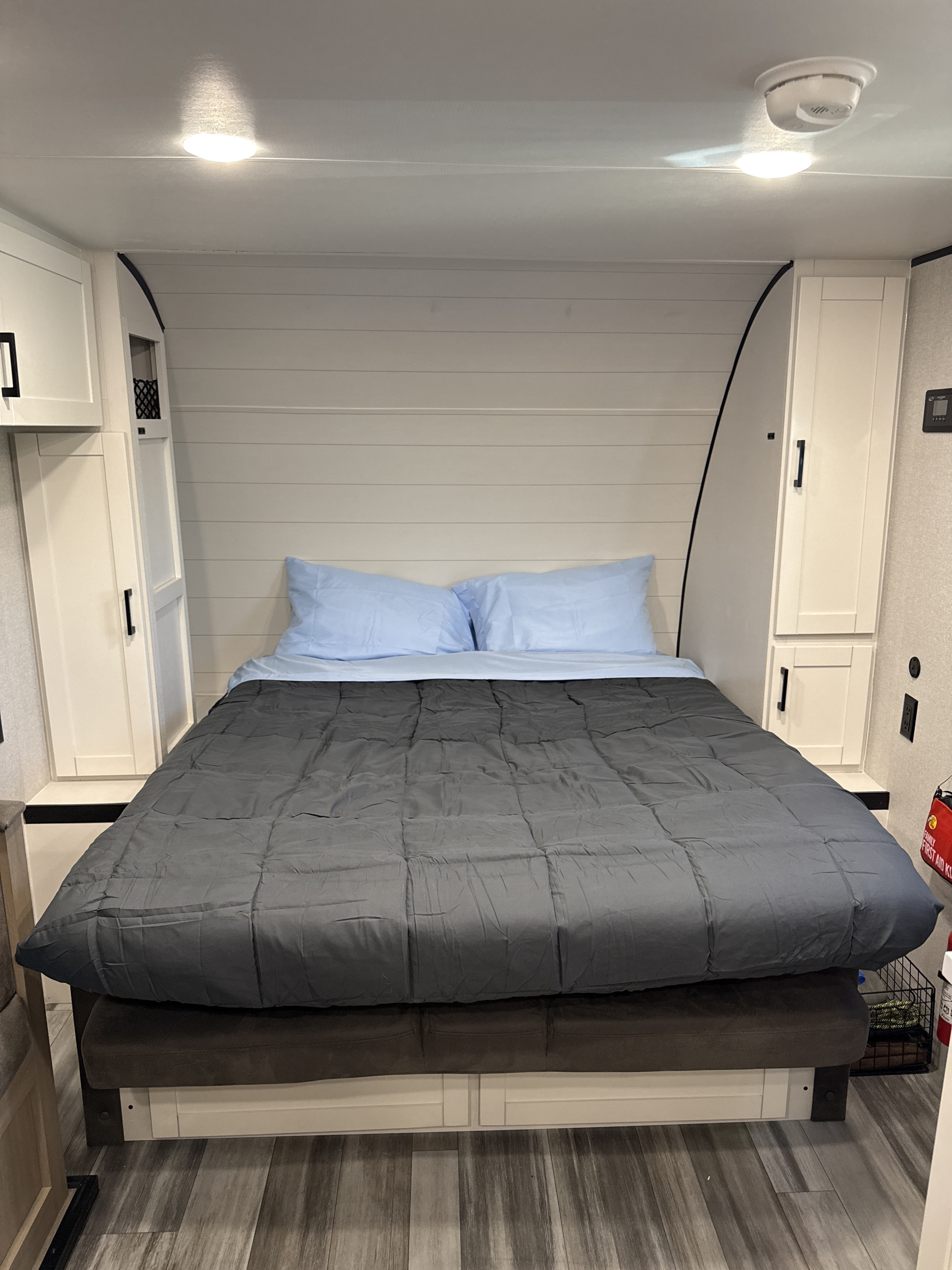 Cozy RV rental bedroom with a neatly made bed, light blue pillows, white built-in cabinets, and a shiplap-style wall.. Jayco Jay Flight SLX Baja Edition 2025
