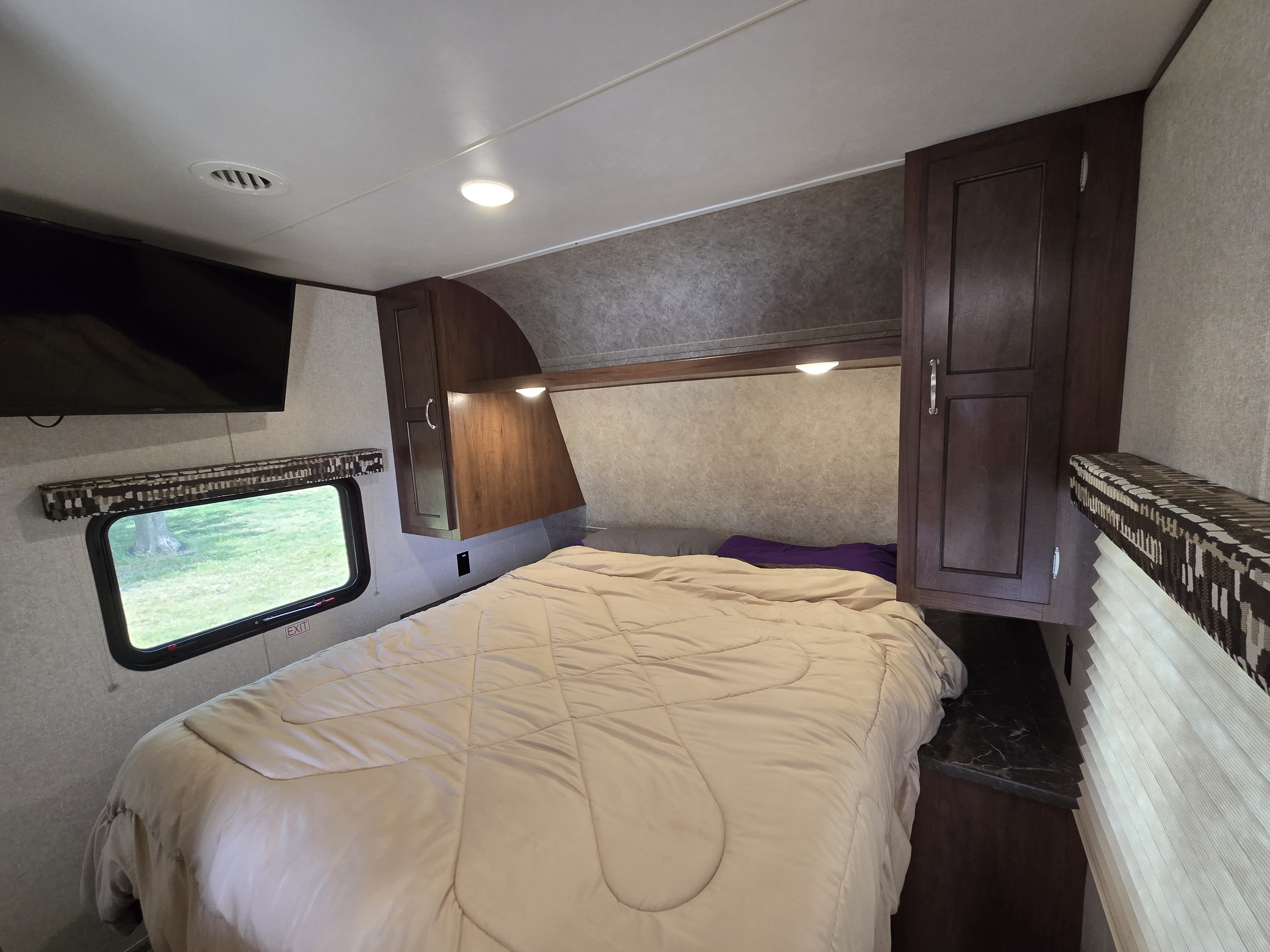RV rental bedroom view: Comfy bed, overhead storage, TV, and window looking out. A cozy and functional sleeping area.. Jayco Jay Flight SLX 2017