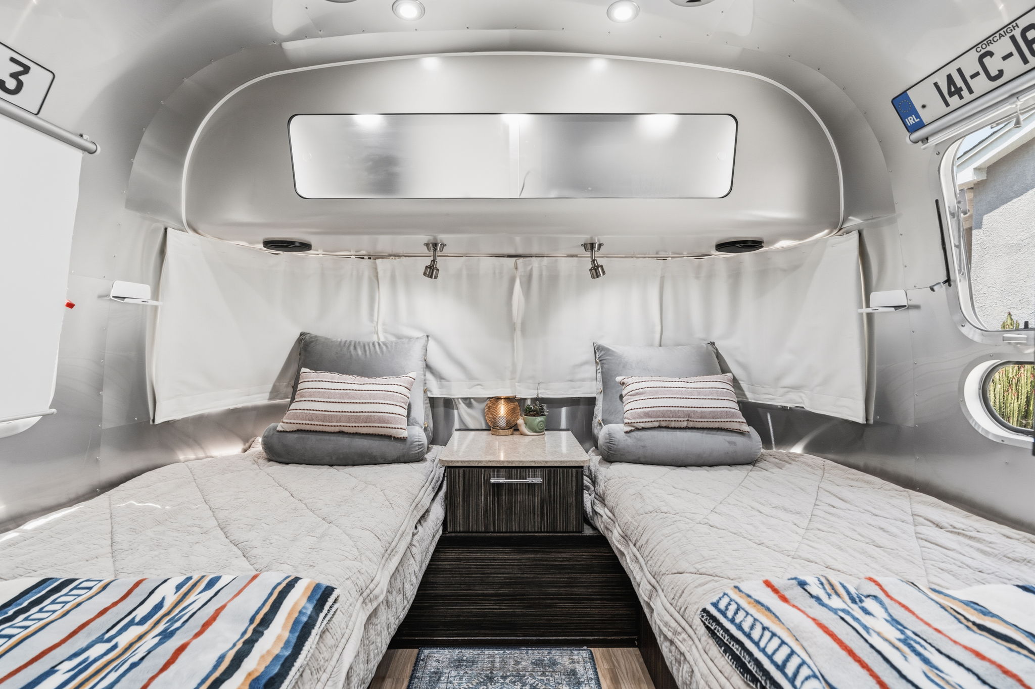 Cozy twin beds inside this Airstream rv rental, with polished silver walls & modern decor for your travel adventures.. Airstream International 2018