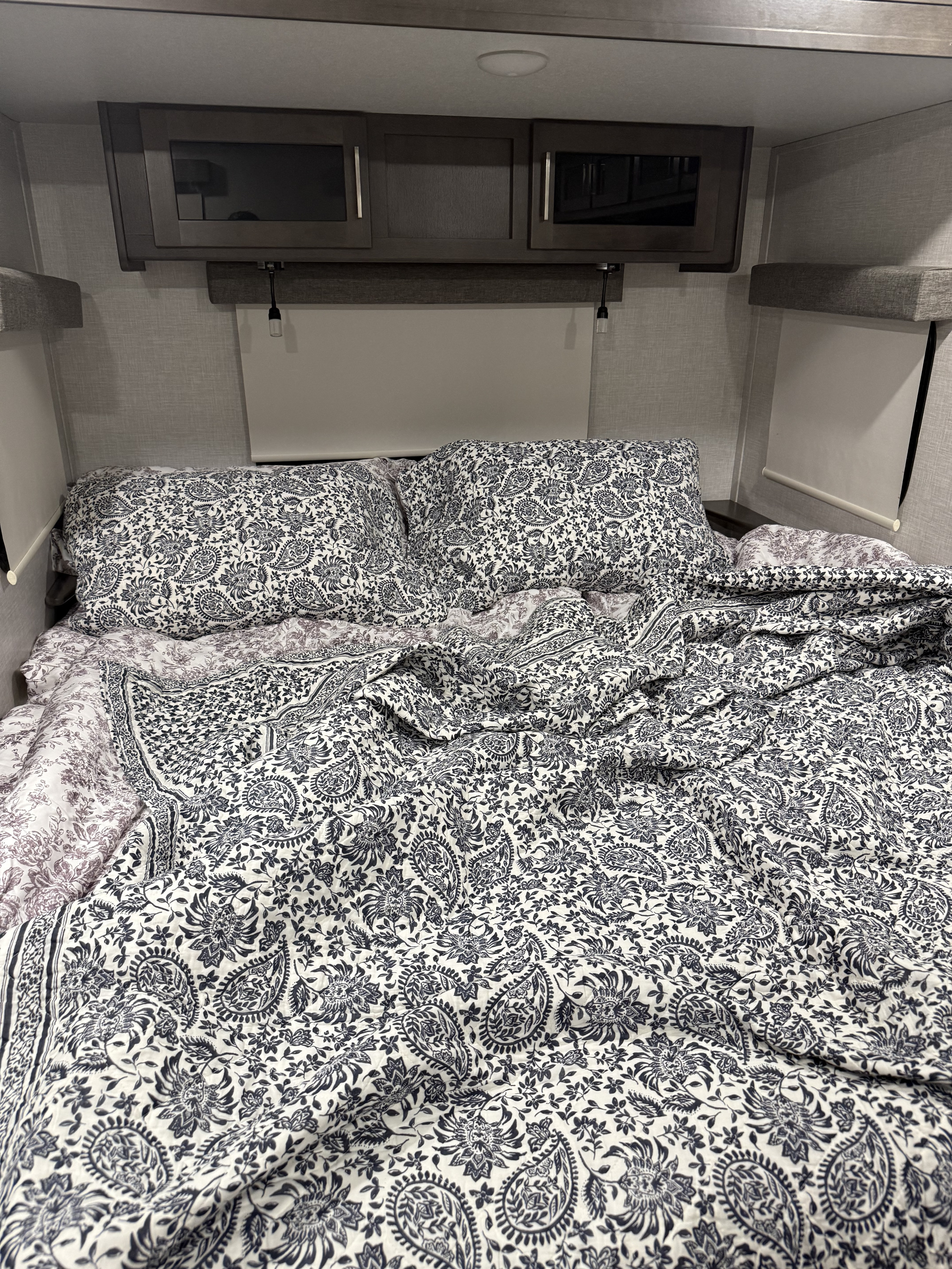 Cozy RV rental bed, patterned bedding & overhead storage, ideal for travel comfort.. Rock wood ultra lite 2912bs 2020