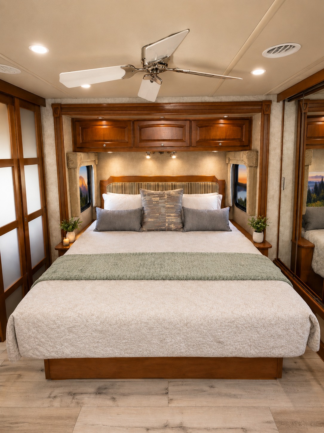 Cozy RV rental bedroom with a comfortable bed, ceiling fan, storage cabinets, and picturesque window views for a relaxing trip.. Winnebago Adventurer 2012