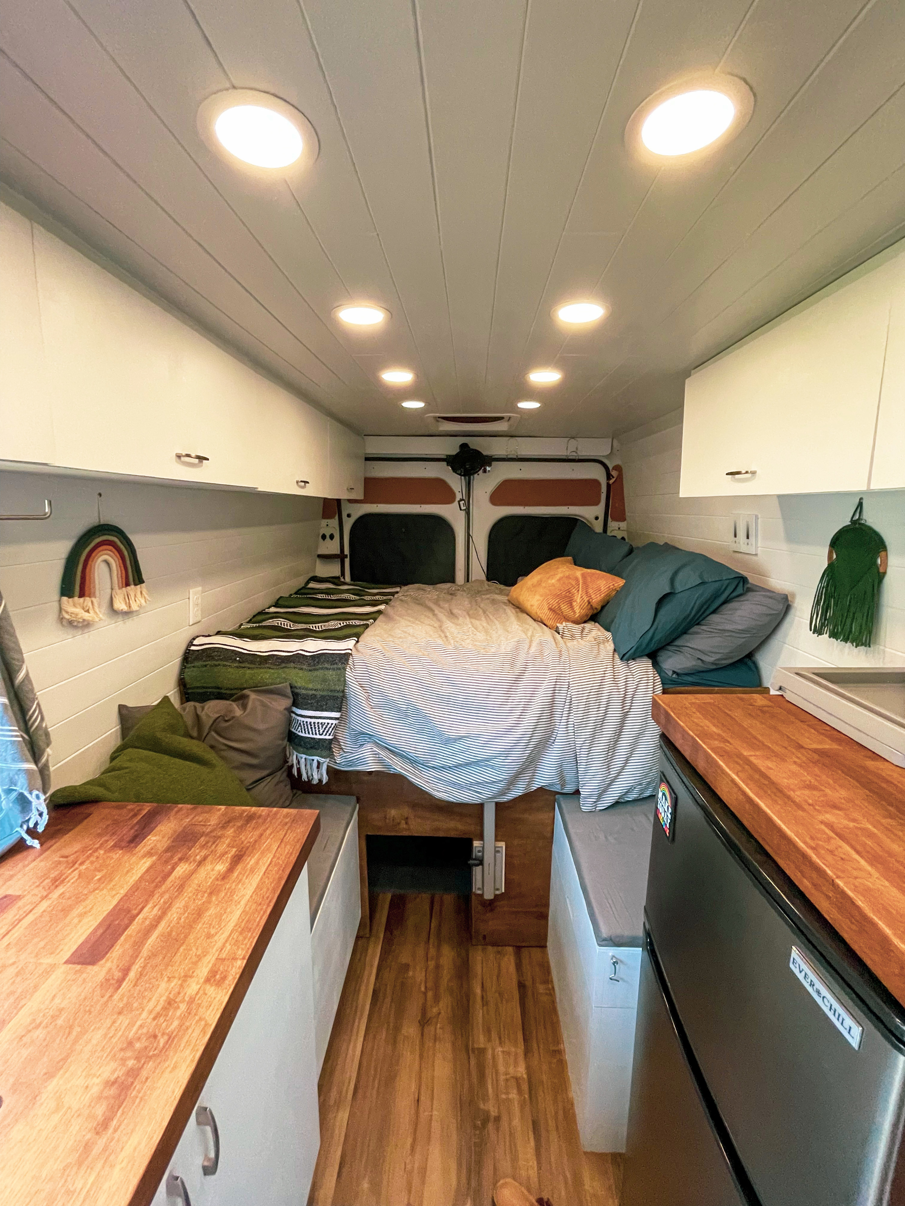 Cozy camper van interior perfect for your next RV rental adventure, featuring a bed, kitchen, and ample storage.. Dodge Promaster 2500 2019