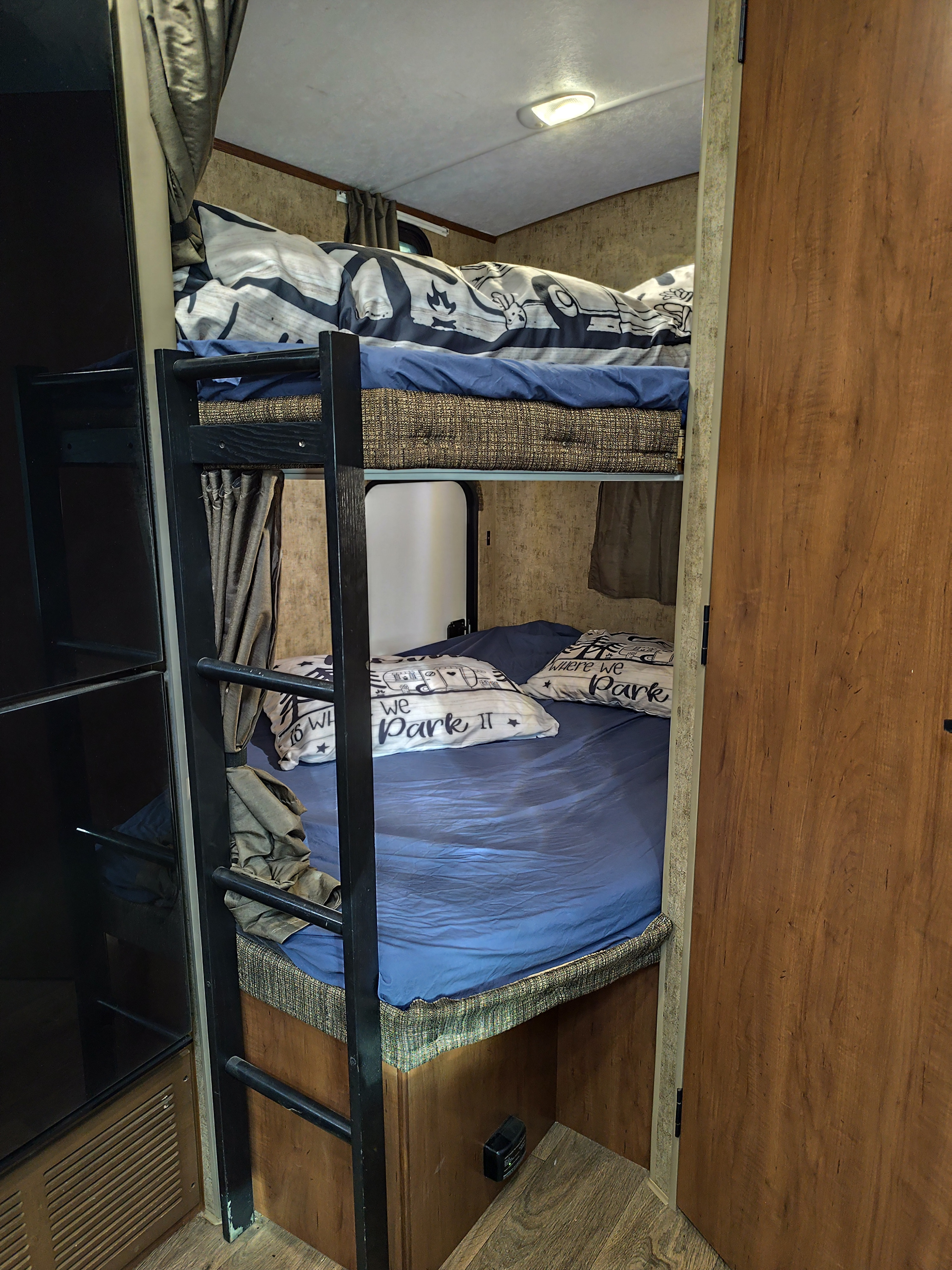 Experience family comfort in this rv rental with cozy bunk beds and fun "Where We Park It" pillows. Perfect for road trips.. Outdoors RV Timber Ridge 2021