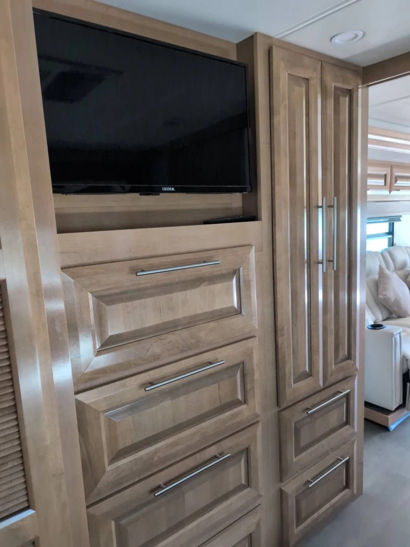 RV rental: Bright RV interior features a TV, light wood cabinetry, drawers, and tall storage, with a glimpse of the living space.. Forest River GEORGETOWN 36D7 2024