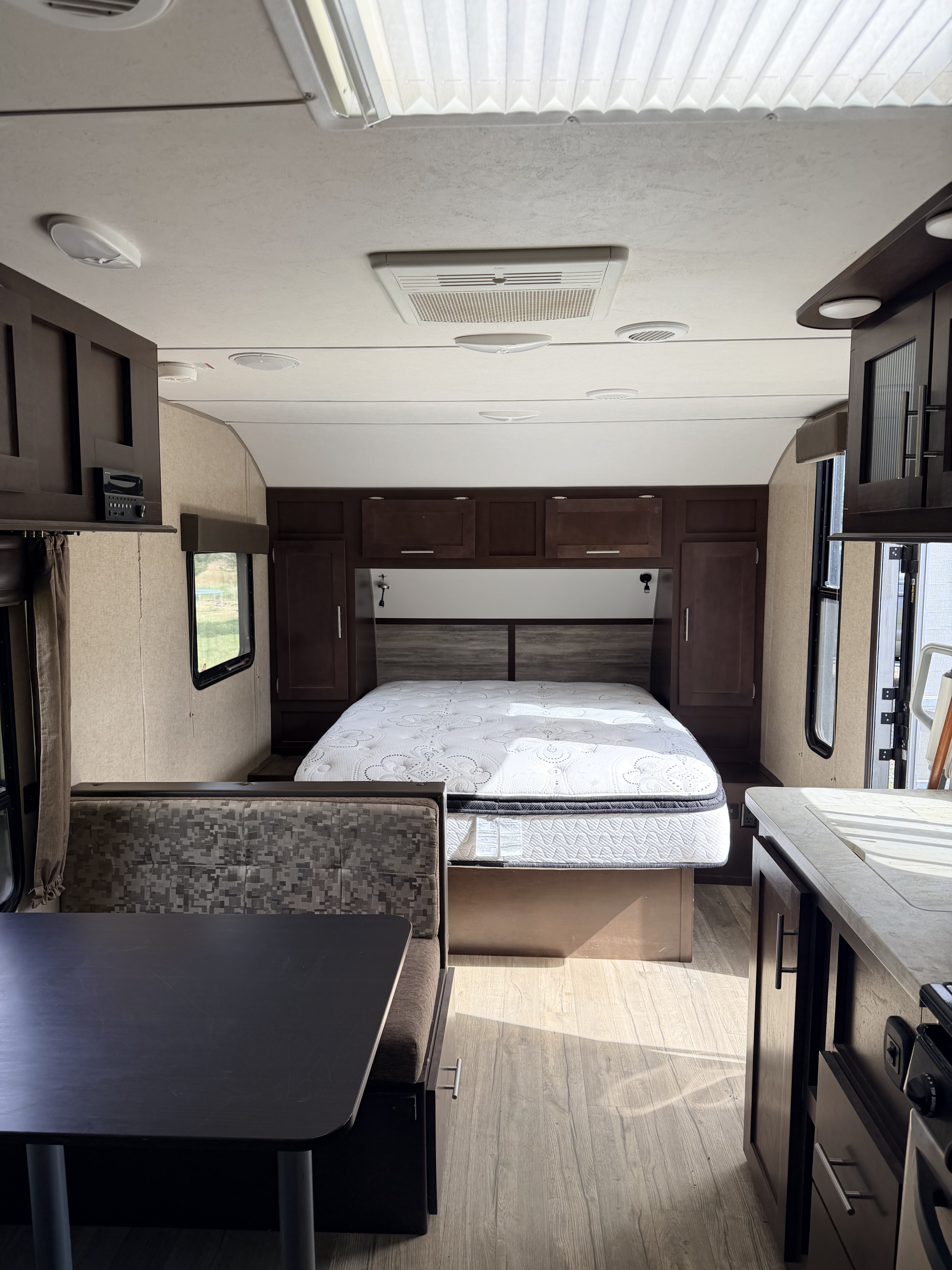 Spacious RV rental interior with a queen bed, dining booth, kitchen counter, and overhead storage. Ideal for road trips.. Forest River Cherokee Grey Wolf 2018