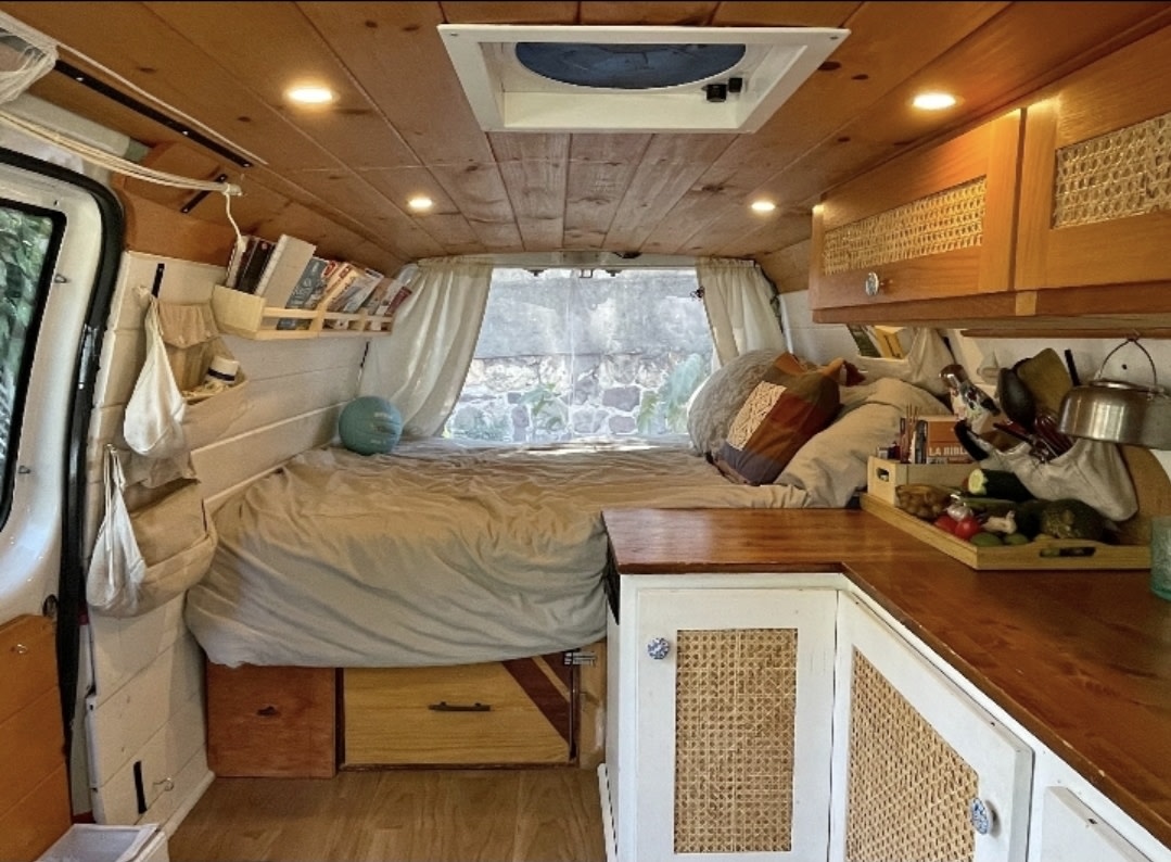 Experience van life in this cozy rv rental. It features a warm wooden interior with a bed, kitchen, and ample storage.. Ford Econoline 2007