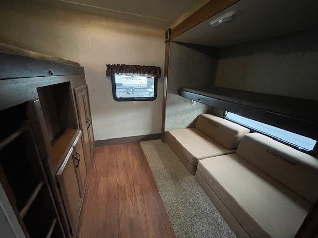 Spacious RV rental bunkhouse featuring multiple bunk beds, fold-out seats, and storage for a comfortable family trip.. Coachmen Freedom Express 2015