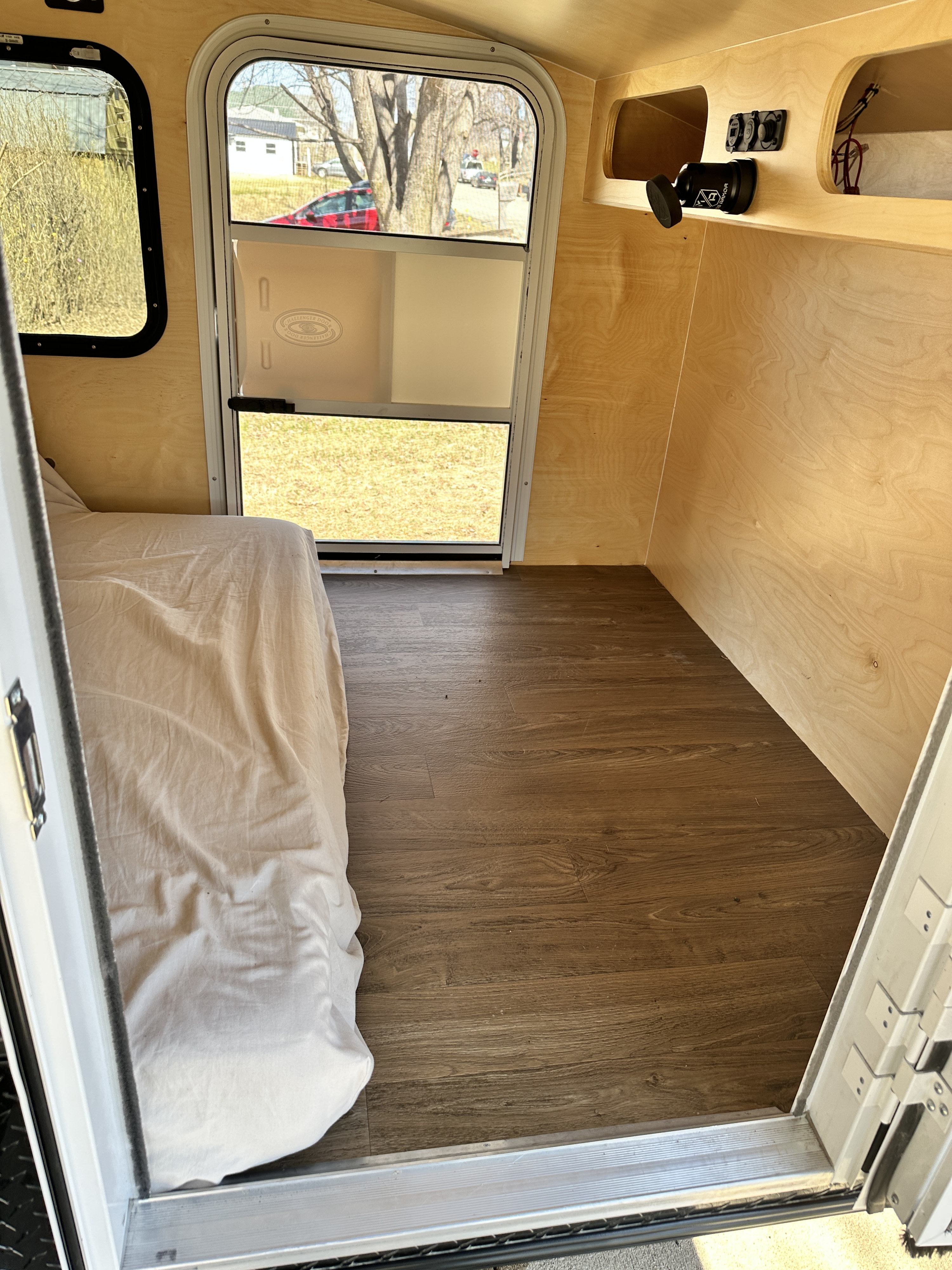 Experience compact living in this RV rental's warm wood interior, featuring a bed, ample storage, and power outlets.. Hiker HD580 2022