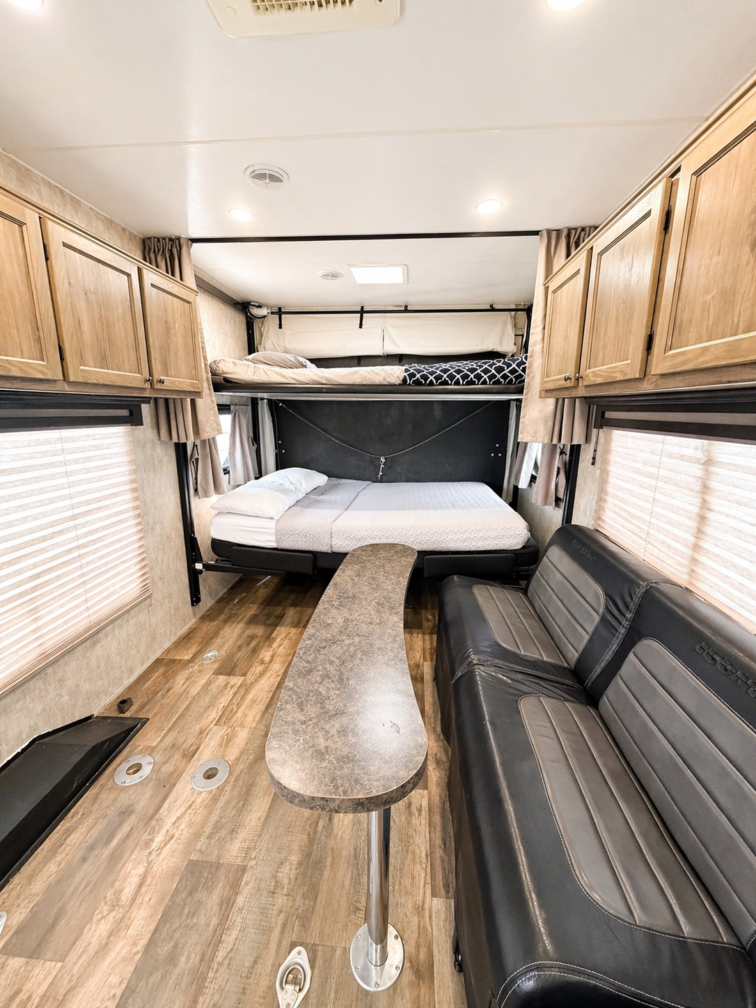RV rental toy hauler interior: versatile space with convertible bunk beds, dining table, sofa, and storage.. Eclipse Recreational Vehicles Iconic 2017
