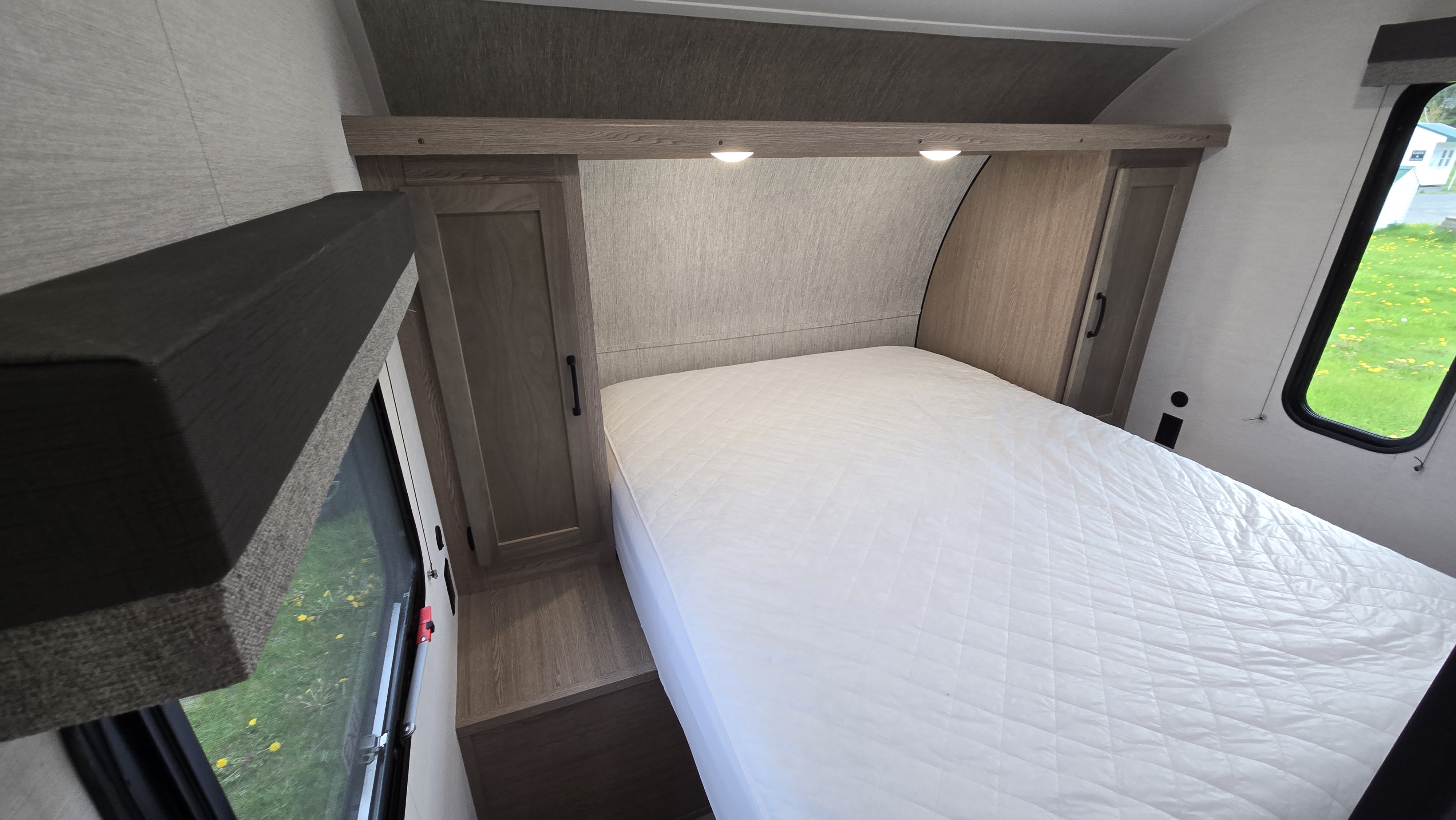 Cozy RV rental bedroom with a comfy bed, integrated storage, ambient lights, and natural light from the window.. Gulf Stream 279BH 2026