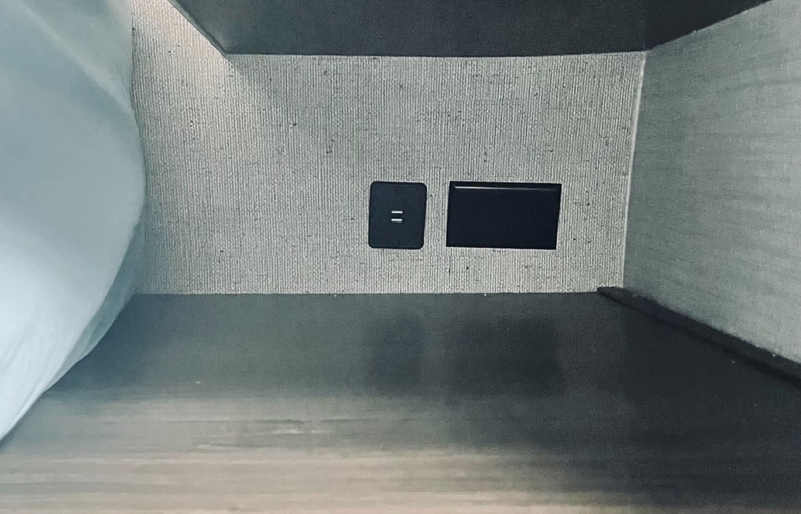 RV rental bunk: textured wall with a USB charging port and a rectangular utility slot for device power.. Keystone RV Bullet Ultra Lite 2019