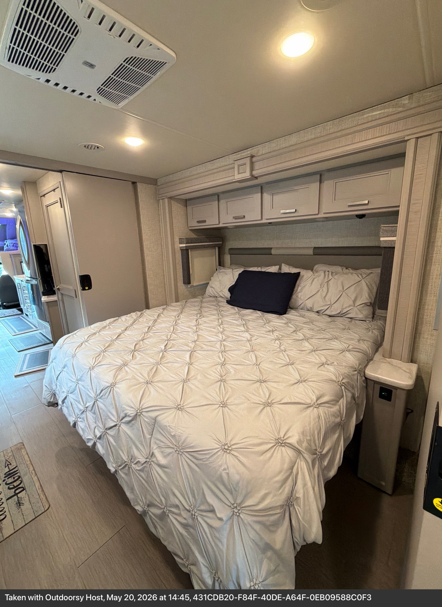 Comfortable RV rental bedroom interior with a large bed, overhead storage, and AC for cozy travel adventures.. Thor Inception 2023