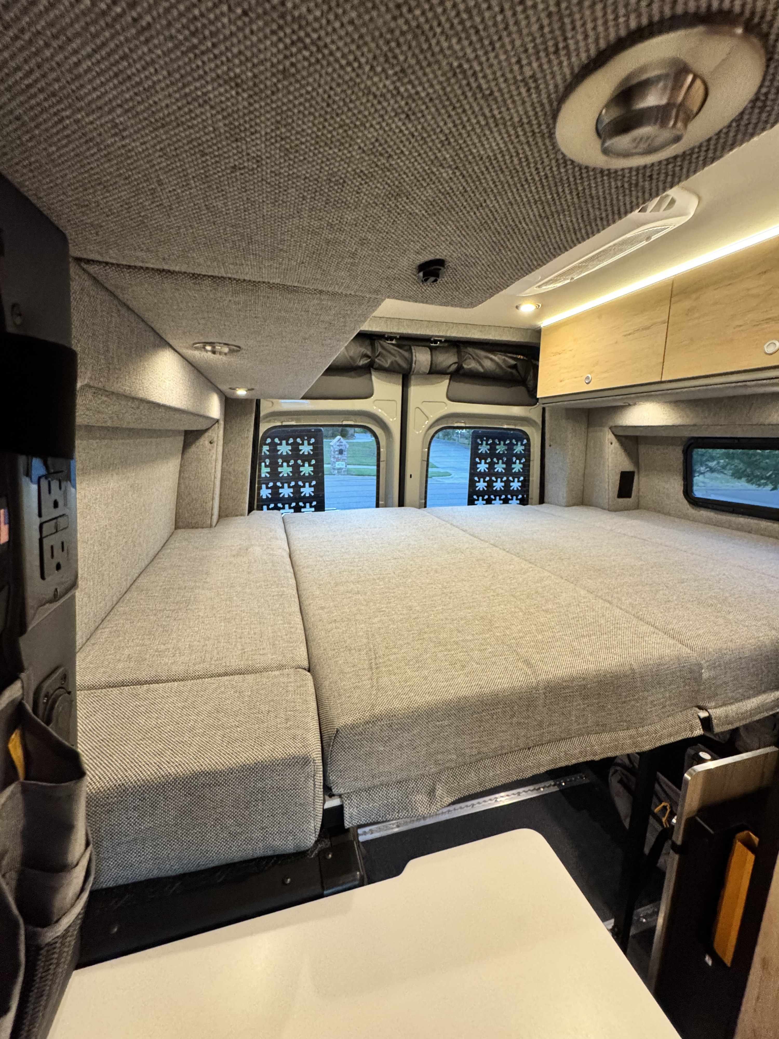 Relaxing RV rental interior with a spacious, modular bed, overhead storage, and ambient lighting.. Storyteller Overland XO 2025
