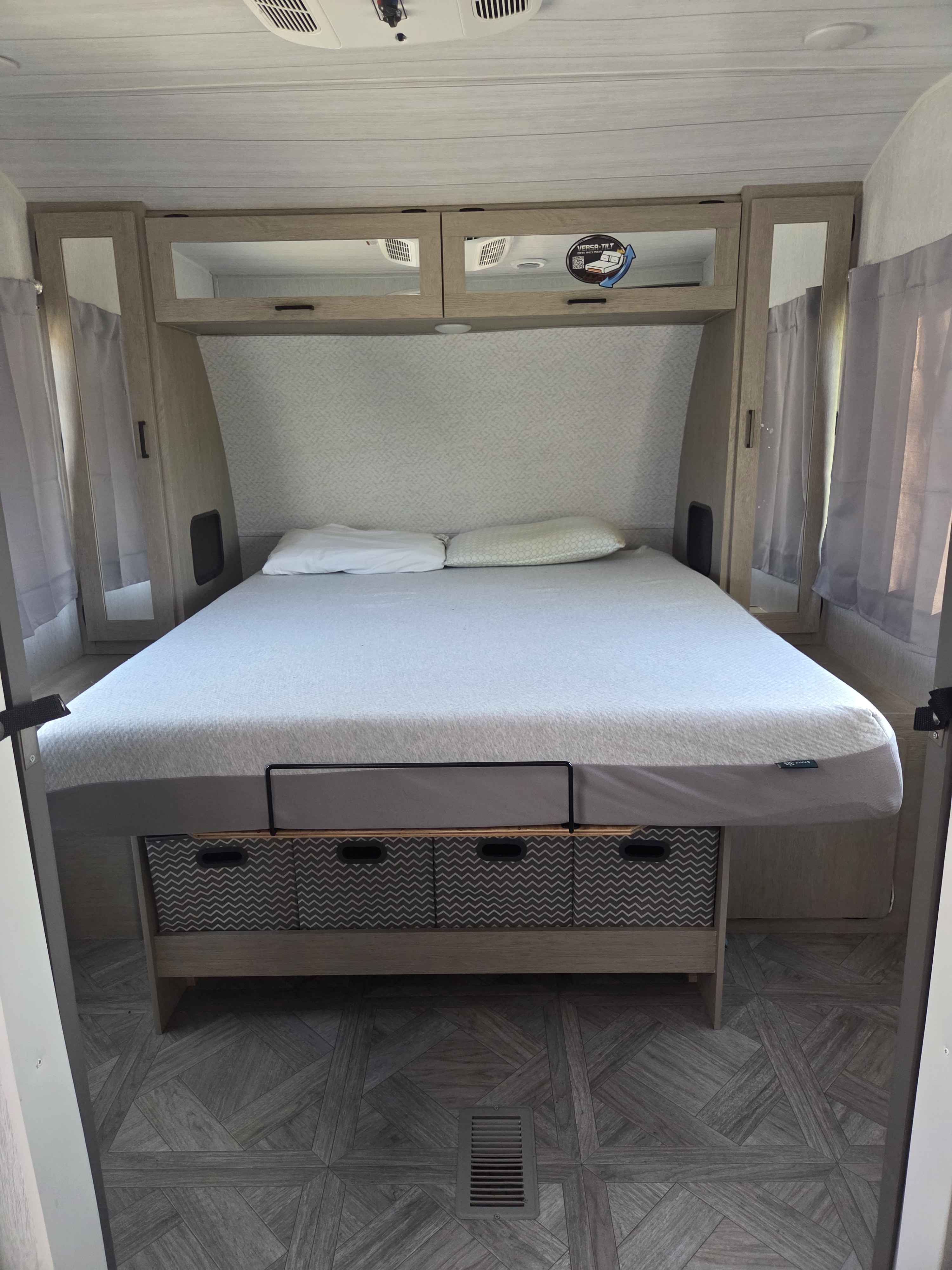 RV rental bedroom: cozy bed with storage bins, overhead cabinets, and modern patterned flooring.. Forest River Salem Platinum 2024