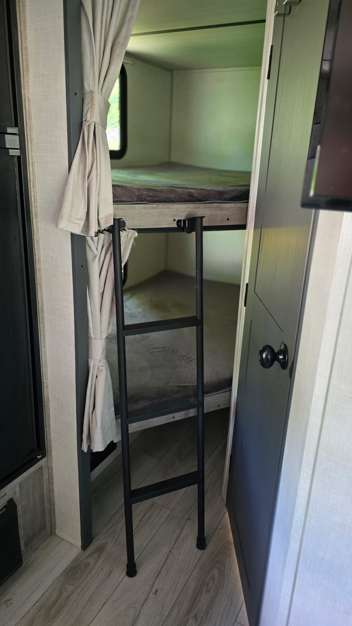 RV rental with cozy bunk beds, ladder, and privacy curtains for a comfortable stay.. Forest River Surveyor Legend 2023