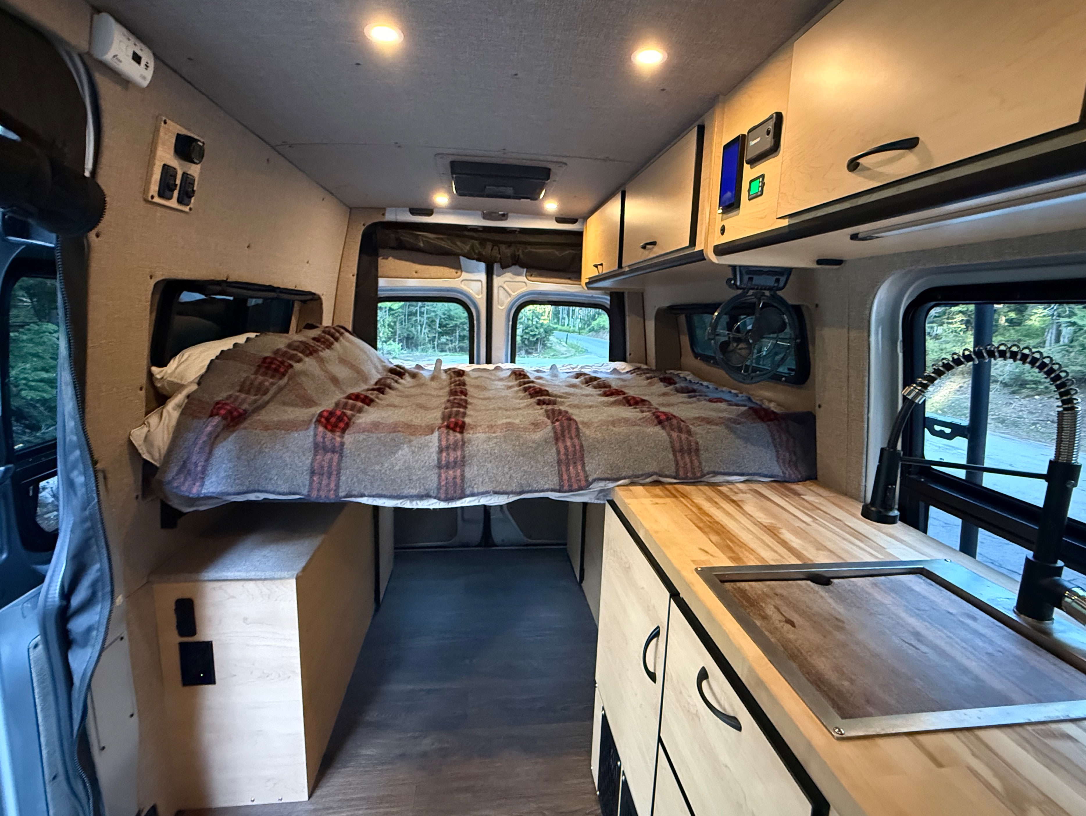Camper van RV rental interior with a comfy bed, kitchen, overhead storage, and controls for your next adventure.. Mercedes-Benz Sprinter 2020
