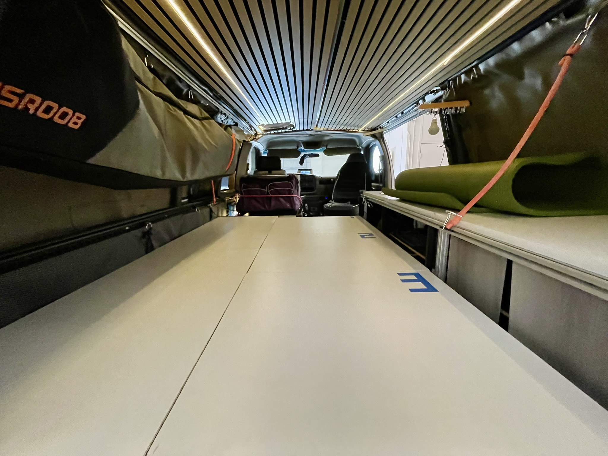 Spacious camper van interior for your next rv rental adventure. Features bed platform, overhead storage, and front cabin view.. Chevy Express 1500 1998