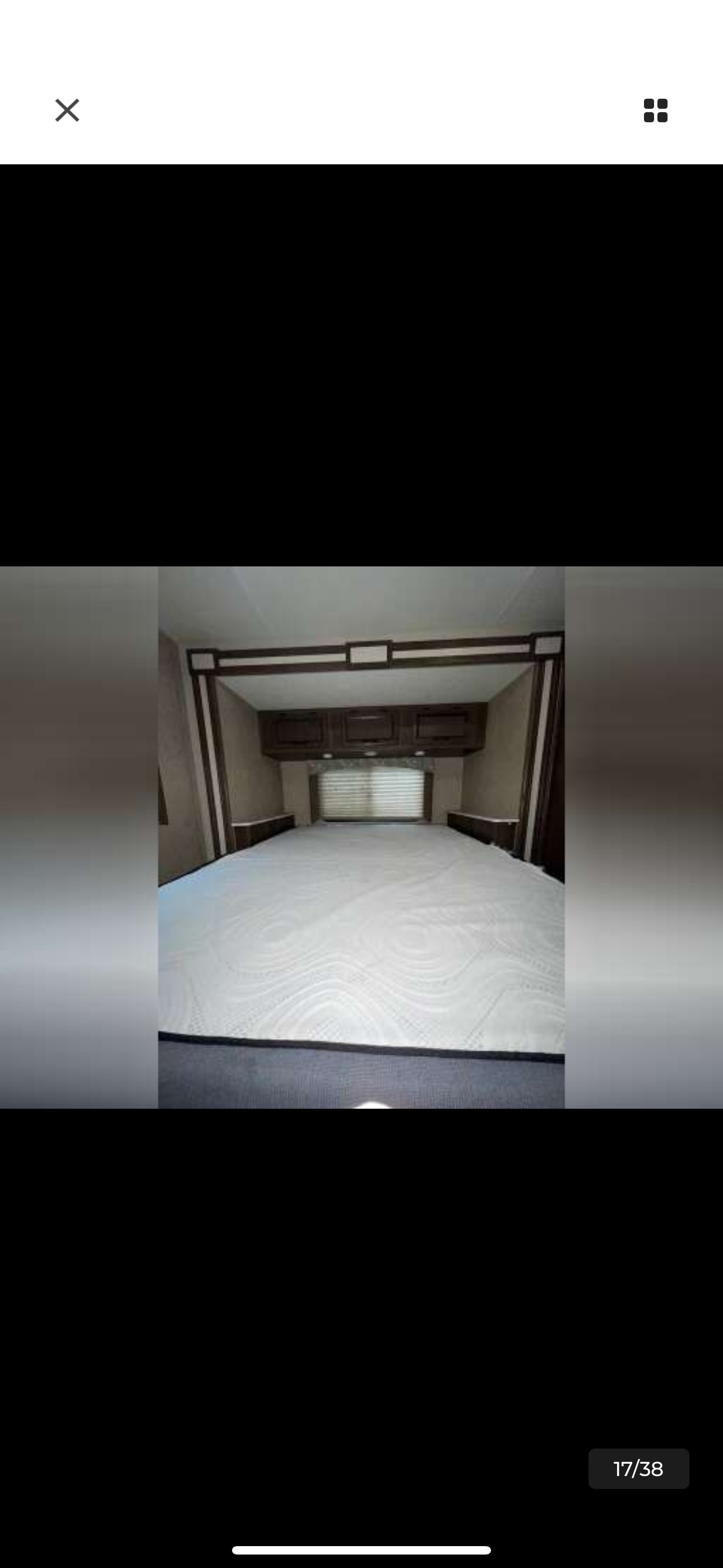 RV rental bedroom features a clean, spacious bed, overhead cabinets, and a window with blinds, ready for your adventure.. Coachmen Freelander 26DS 2019
