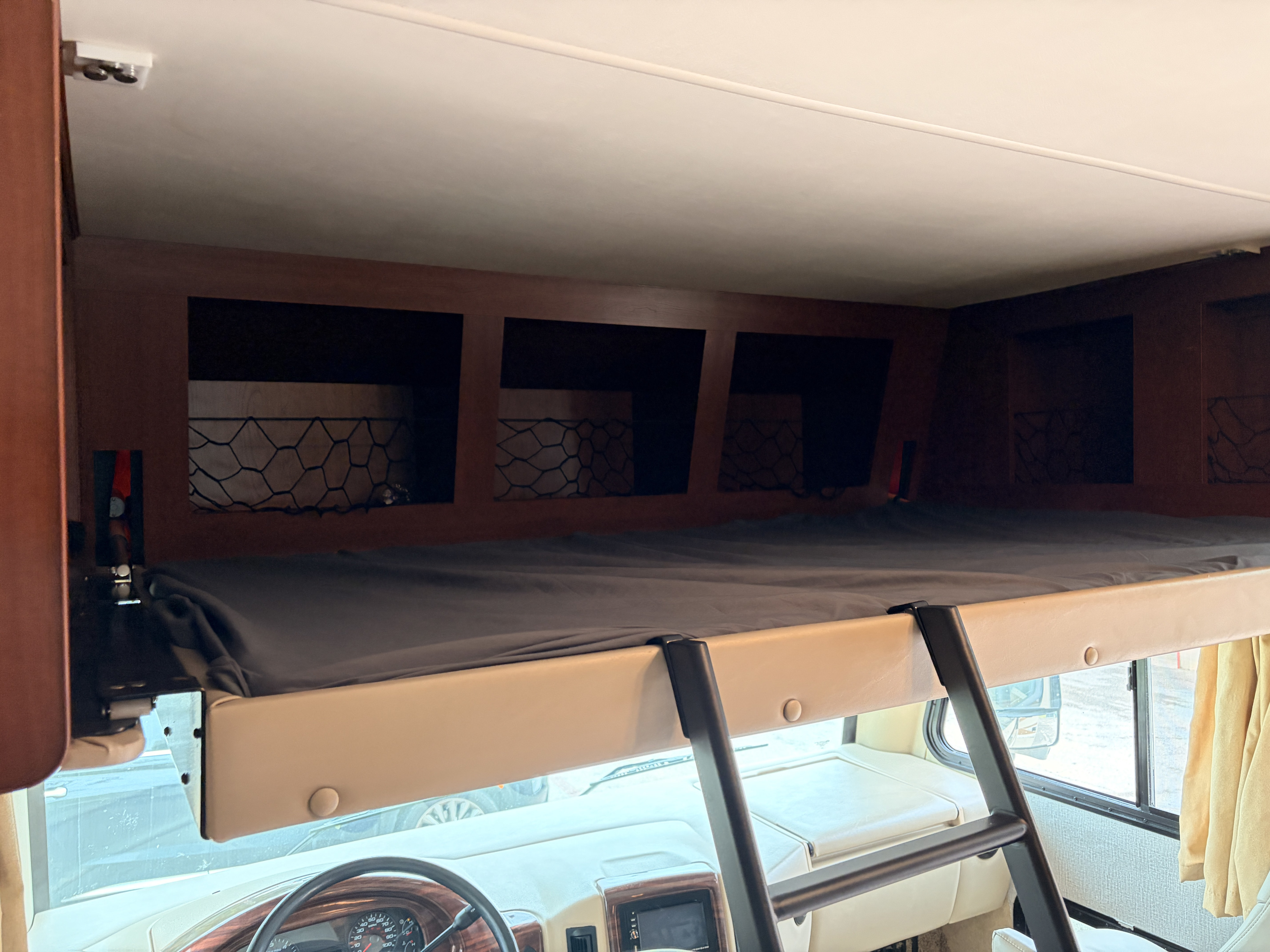 This RV rental features a comfortable overhead bunk bed with storage above the driver's area, accessible via a ladder.. Thor Motor Coach A.C.E 2015