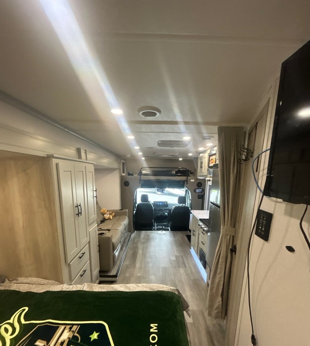 Spacious RV rental interior featuring a bed, kitchen, sofa, and cockpit view. This modern, well-lit mobile home awaits your adventure.. Isata 3 Series 2026