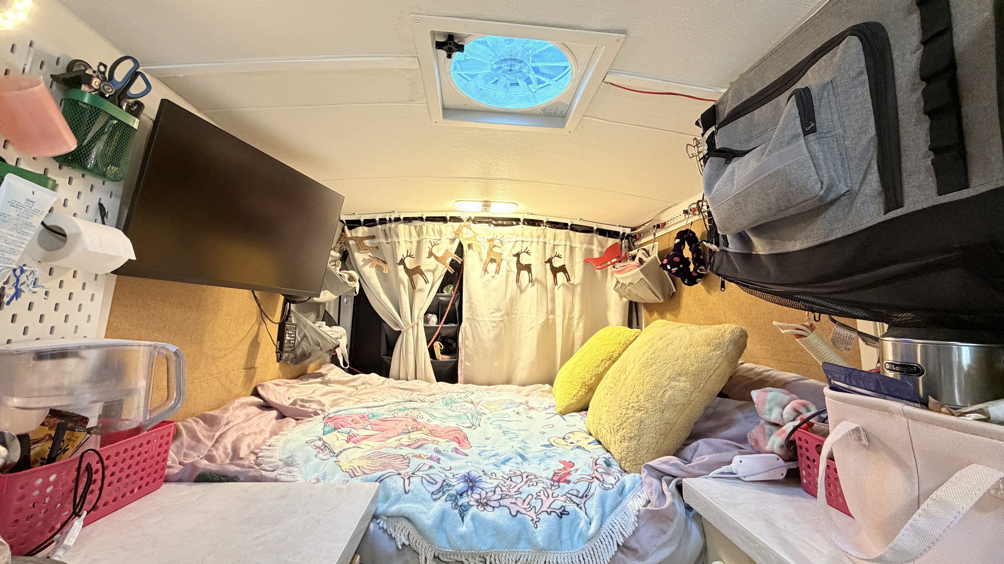 This RV rental offers a compact bedroom setup with a comfy bed, mounted TV, and organized storage for practical small space living.. Ford Transit custom 2018