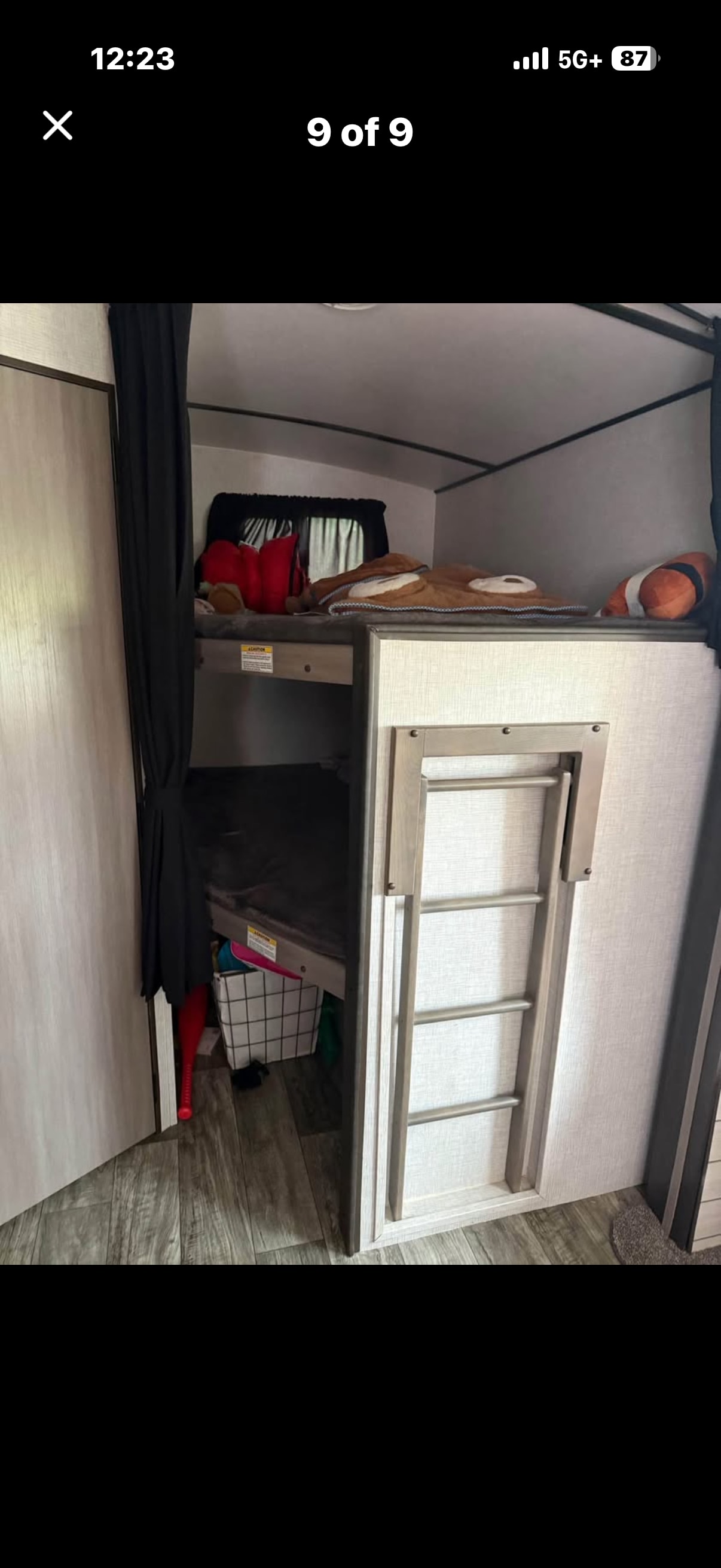 Cozy RV rental bunk beds with ladder & curtain. Plush toys rest on the upper bunk, ready for adventures.. Crossroads RV Sunset Trail Super Lite 2021