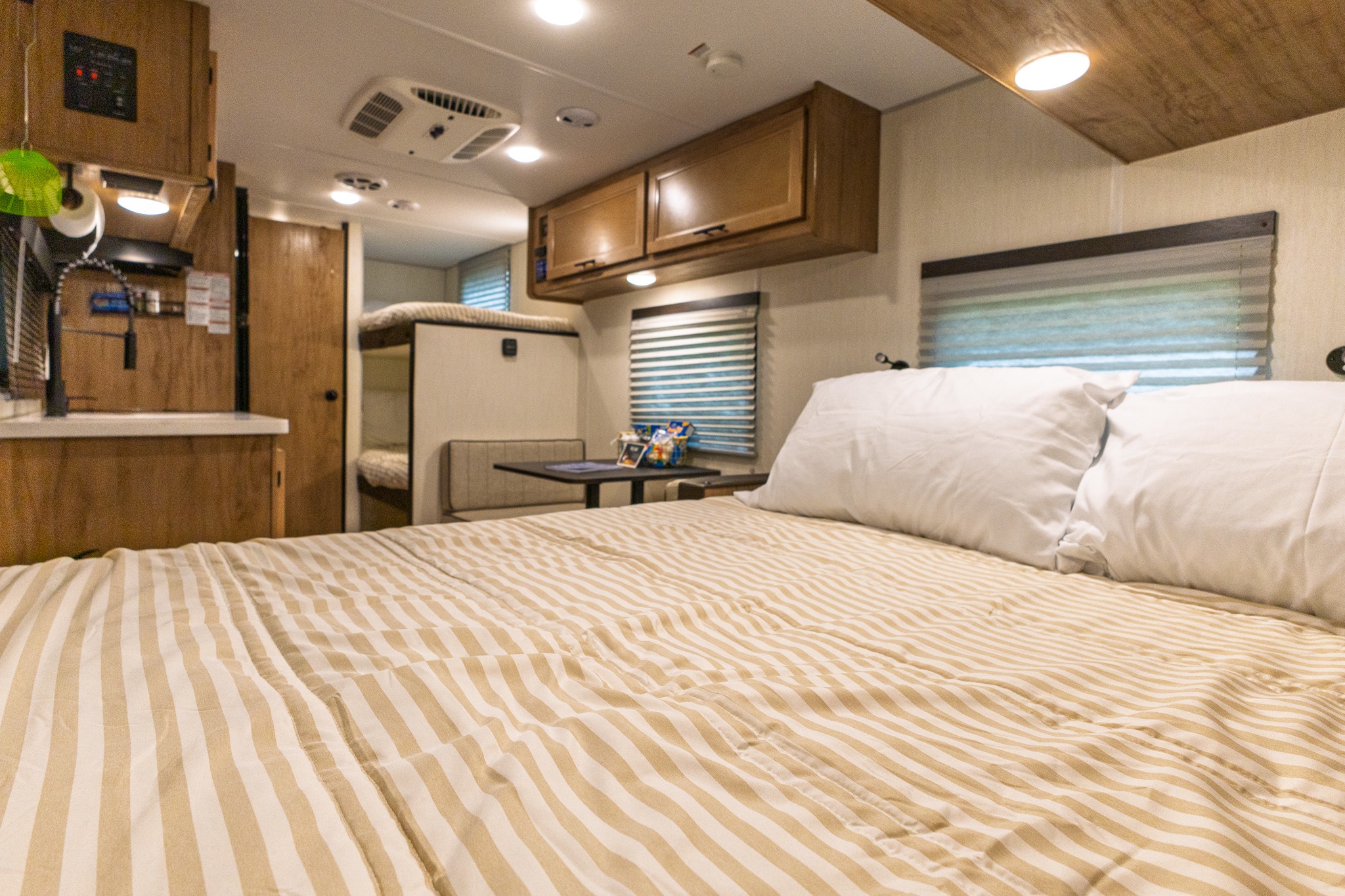 View from the master bed in this RV rental, showing the kitchen, dinette, and bunk beds. Great for road trips!. Forest River Cherokee Wolf Pup Black Label 2025