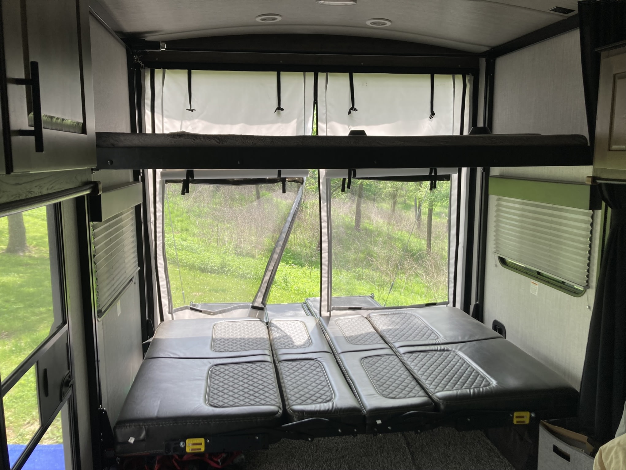 RV rental interior: bunk beds, modular seating/beds, and an open screened view of nature. Perfect for your next camper adventure.. Heartland Torque T314 2021