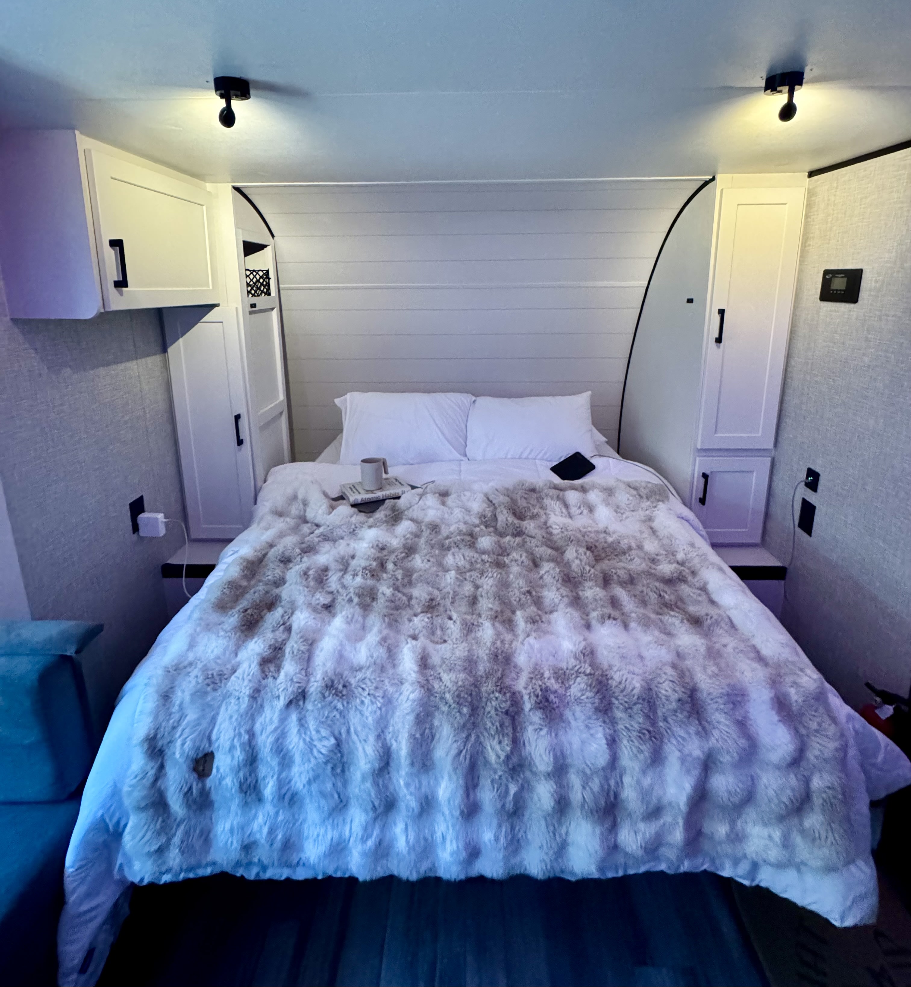 A comfortable rv rental bedroom with a plush faux fur blanket, white cabinets flanking the bed, and soft lighting.. Jayco Jay Flight SLX Baja Edition 2025