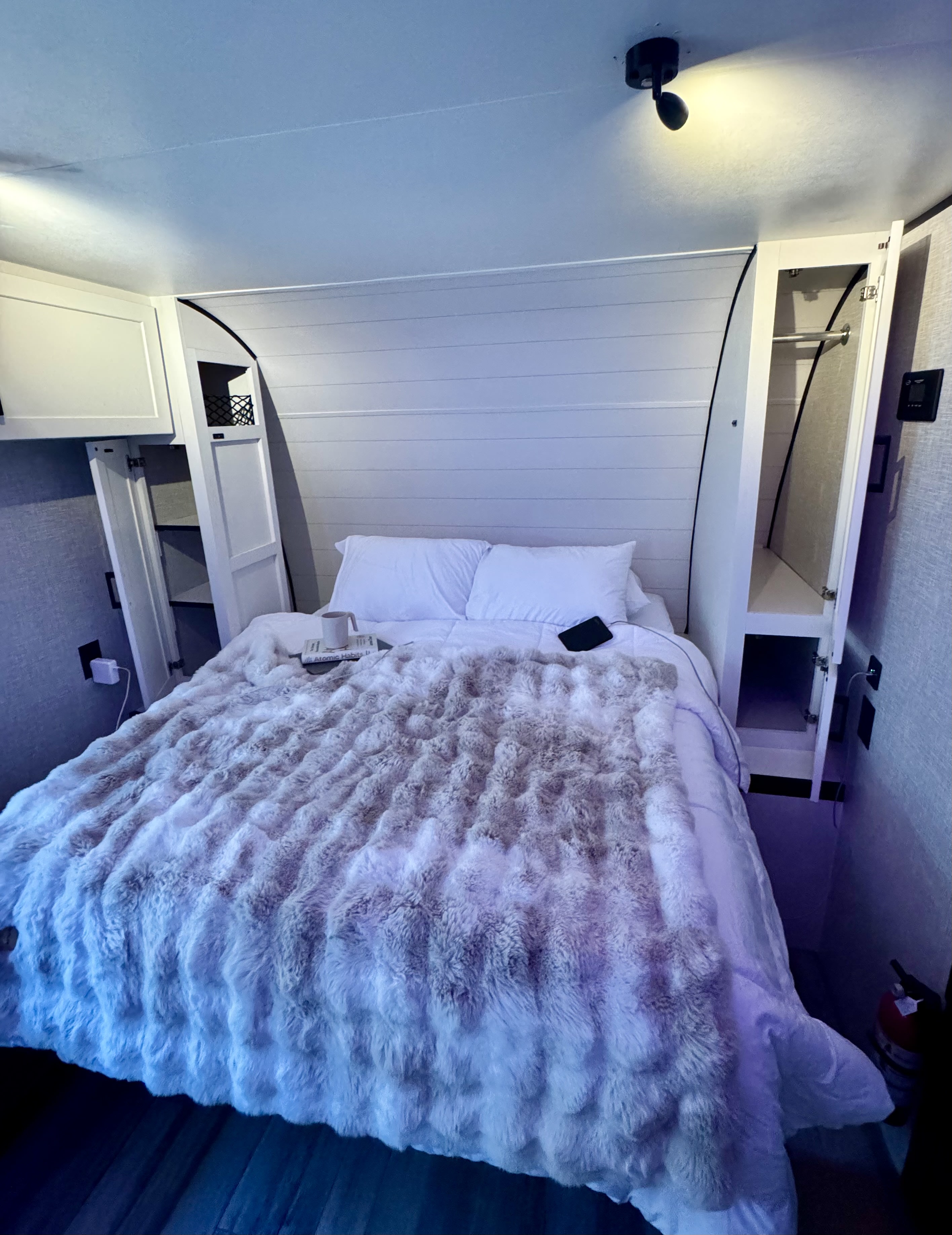 Cozy RV rental bedroom features a comfy bed with a fluffy blanket, built-in storage, and personal items. Perfect for travel.. Jayco Jay Flight SLX Baja Edition 2025